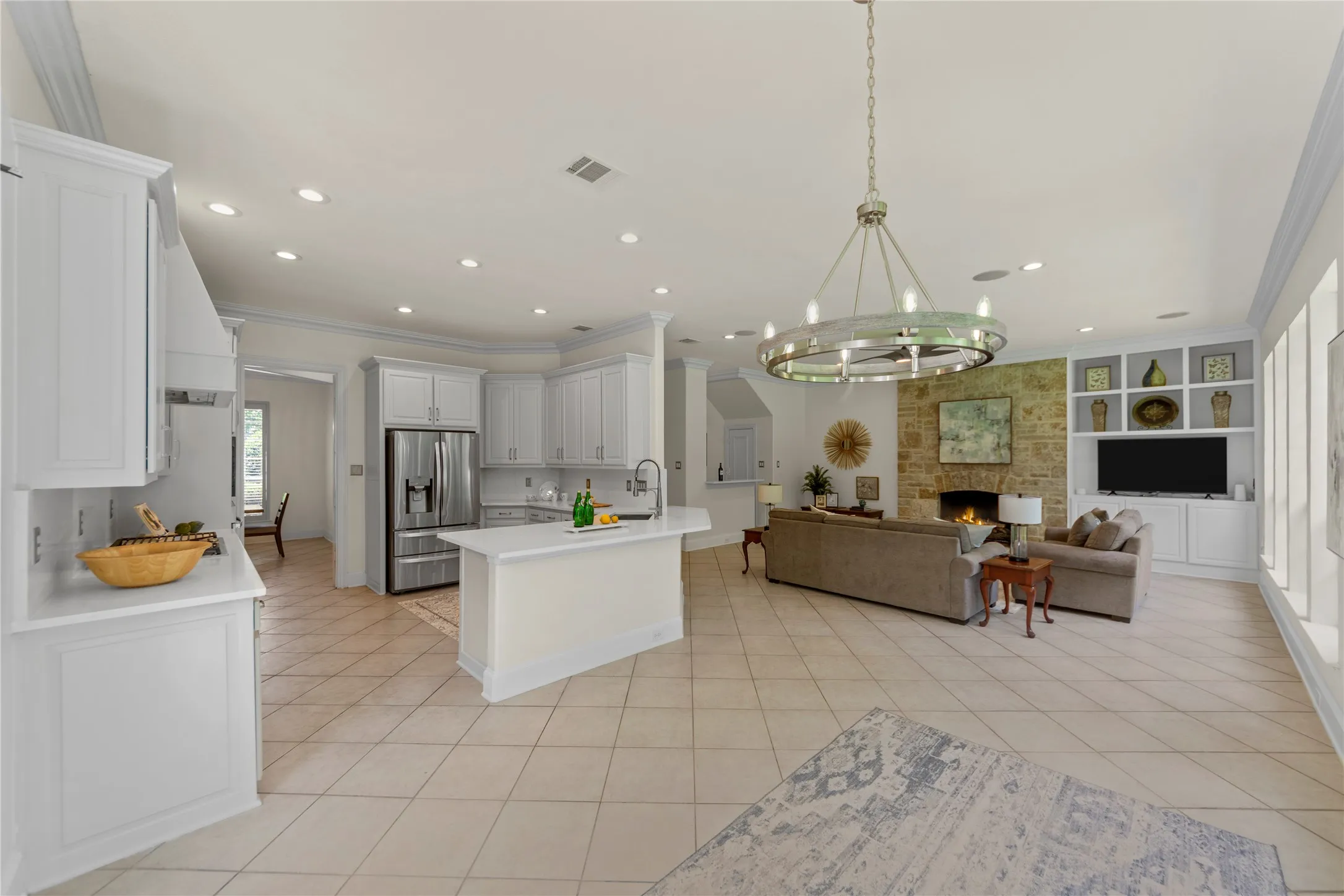 The beautifully updated kitchen is bright, modern, and designed for both everyday living and entertaining. Featuring new quartz countertops, fresh designer paint, updated cabinetry, a stunning new vent hood, and new stainless steel appliances, the space blends timeless elegance with modern functionality. Oversized windows fill the kitchen and breakfast area with natural light while offering peaceful views of the lush backyard and pool.Open to the spacious family room, this inviting layout creates the perfect gathering space for family and guests alike. The large family room showcases a striking floor-to-ceiling stone fireplace, custom built-ins, recessed lighting, and walls of windows that bring the outdoors in. Light, bright, and airy throughout, this open-concept living area feels warm, welcoming, and ideal for entertaining.