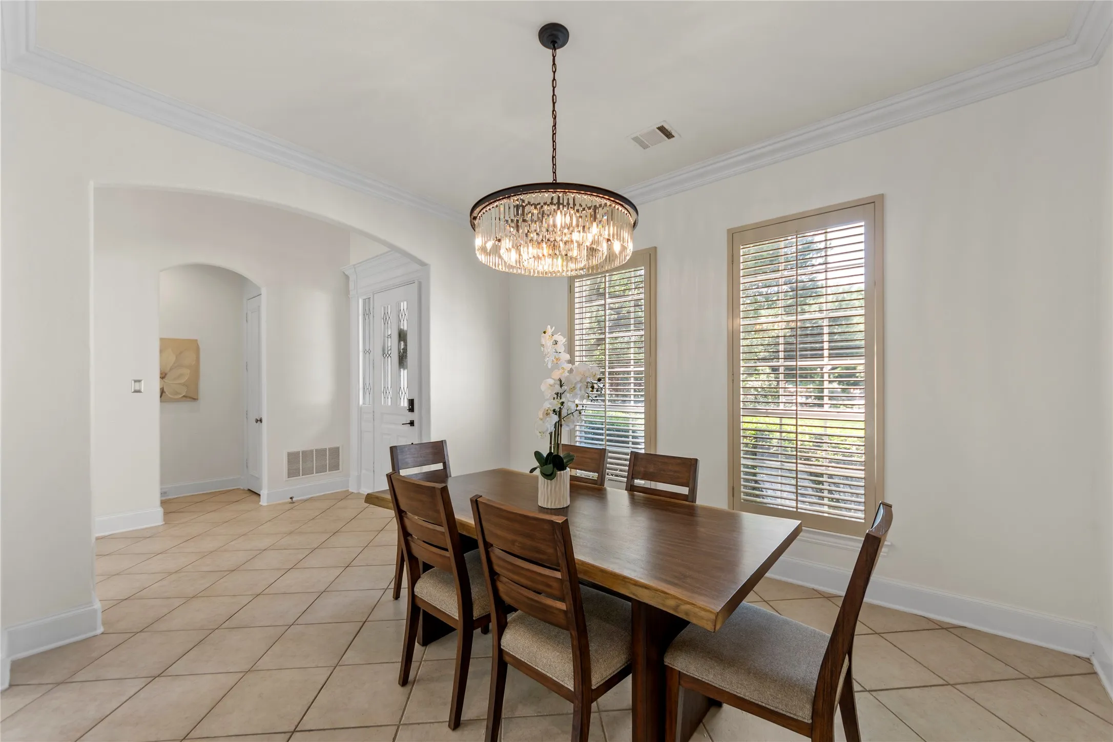 The formal living and dining areas are filled with natural light and showcase soaring ceilings, oversized windows, and an open, airy feel. Fresh updated paint, elegant new light fixtures, and clean modern finishes create a bright and welcoming atmosphere perfect for both everyday living and entertaining. The spacious formal dining room offers a refined setting for gatherings, while the formal living area overlooks the beautifully landscaped backyard, bringing in peaceful garden views and abundant sunlight.
