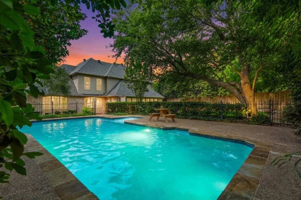 The oversized backyard is a true private retreat, surrounded by mature trees and lush landscaping that create a peaceful, resort-style setting rarely found in Dallas. Enjoy a sparkling pool, expansive patio spaces perfect for entertaining, and an additional large grassy yard with a charming deck area — ideal for outdoor gatherings, play, pets, or simply relaxing under the trees.With multiple outdoor living spaces, this home offers the perfect blend of privacy, nature, and functionality, creating an exceptional indoor-outdoor lifestyle.