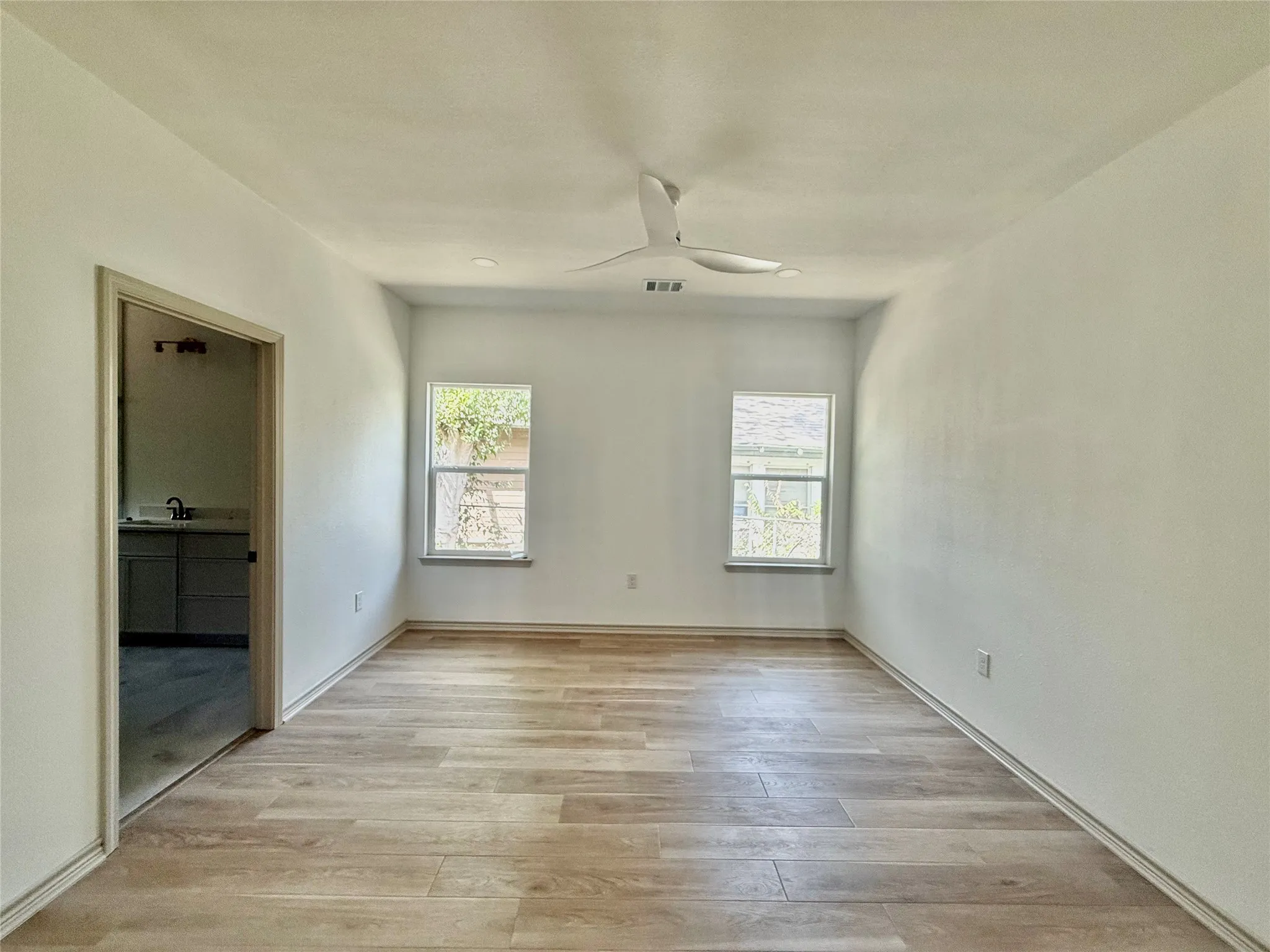Wood-finish flooring throughout, two windows, and a contemporary ceiling​​‌​​​​‌​​‌‌​‌‌​​​‌‌​‌​‌​‌​​​‌​​ fan