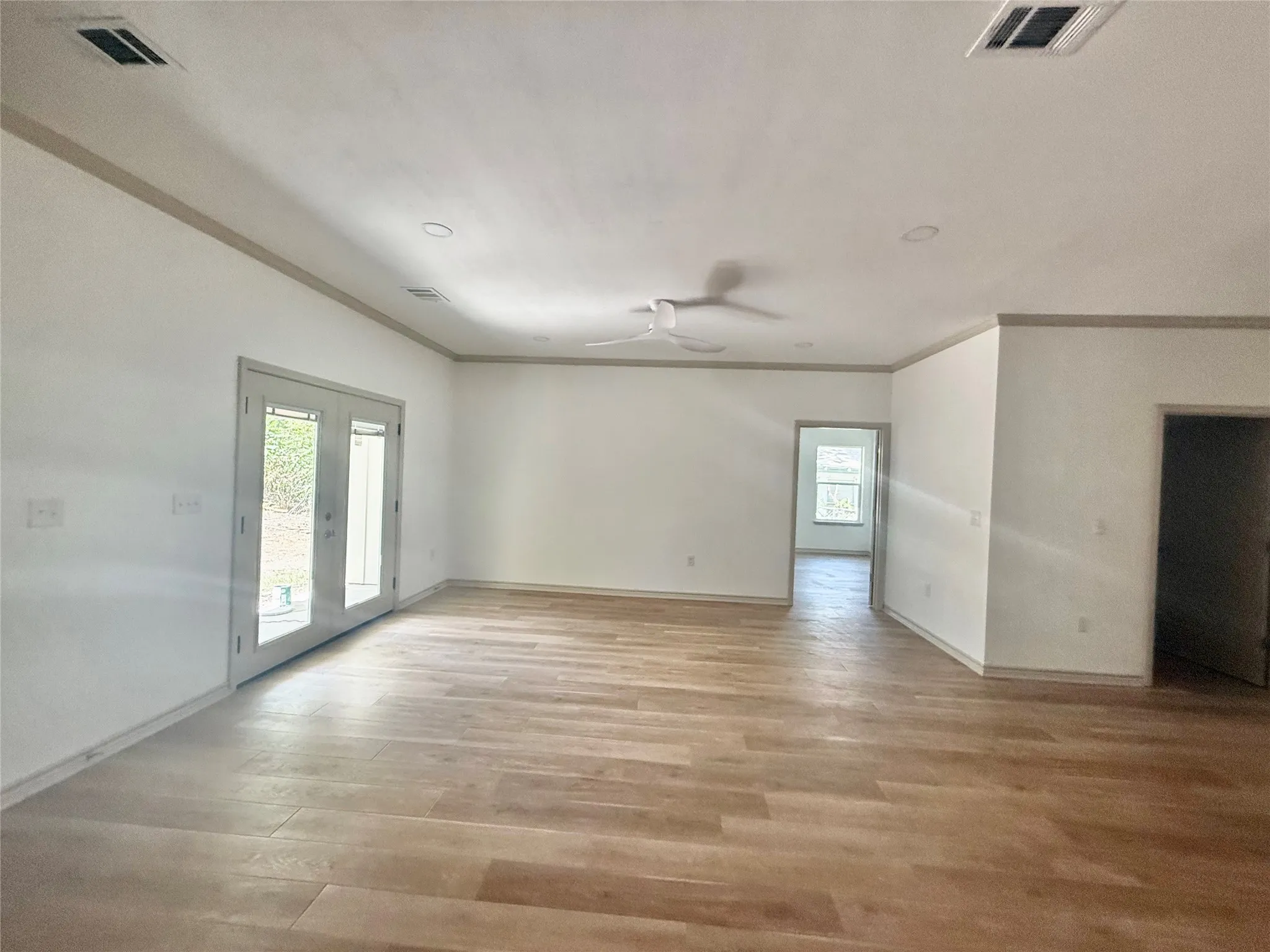Spacious room featuring wood-finish flooring, recessed lighting, and a ceiling fan