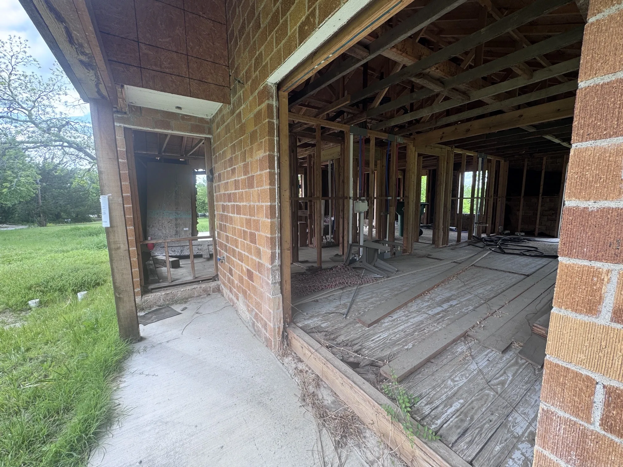 Brick exterior with exposed framing and wood subflooring