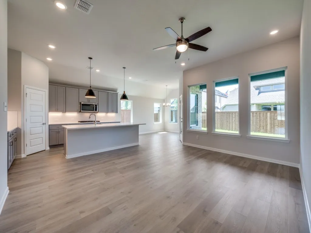 The open concept design of this wonderful home features beautiful flooring, walls of windows, a dream kitchen and so much more!