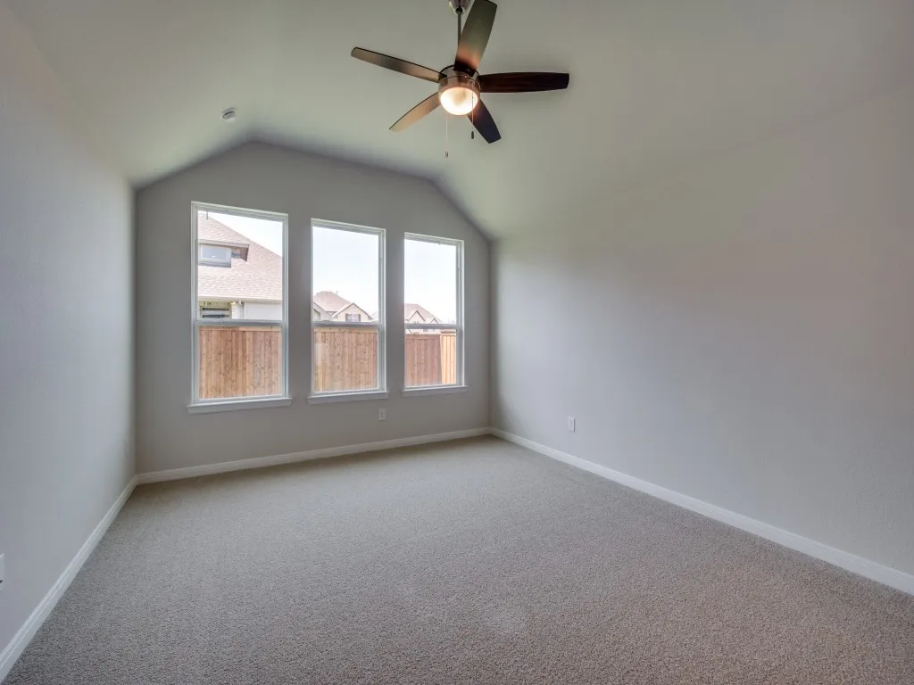 A wall of windows provides a peaceful and relaxing back yard view in this owner's suite.