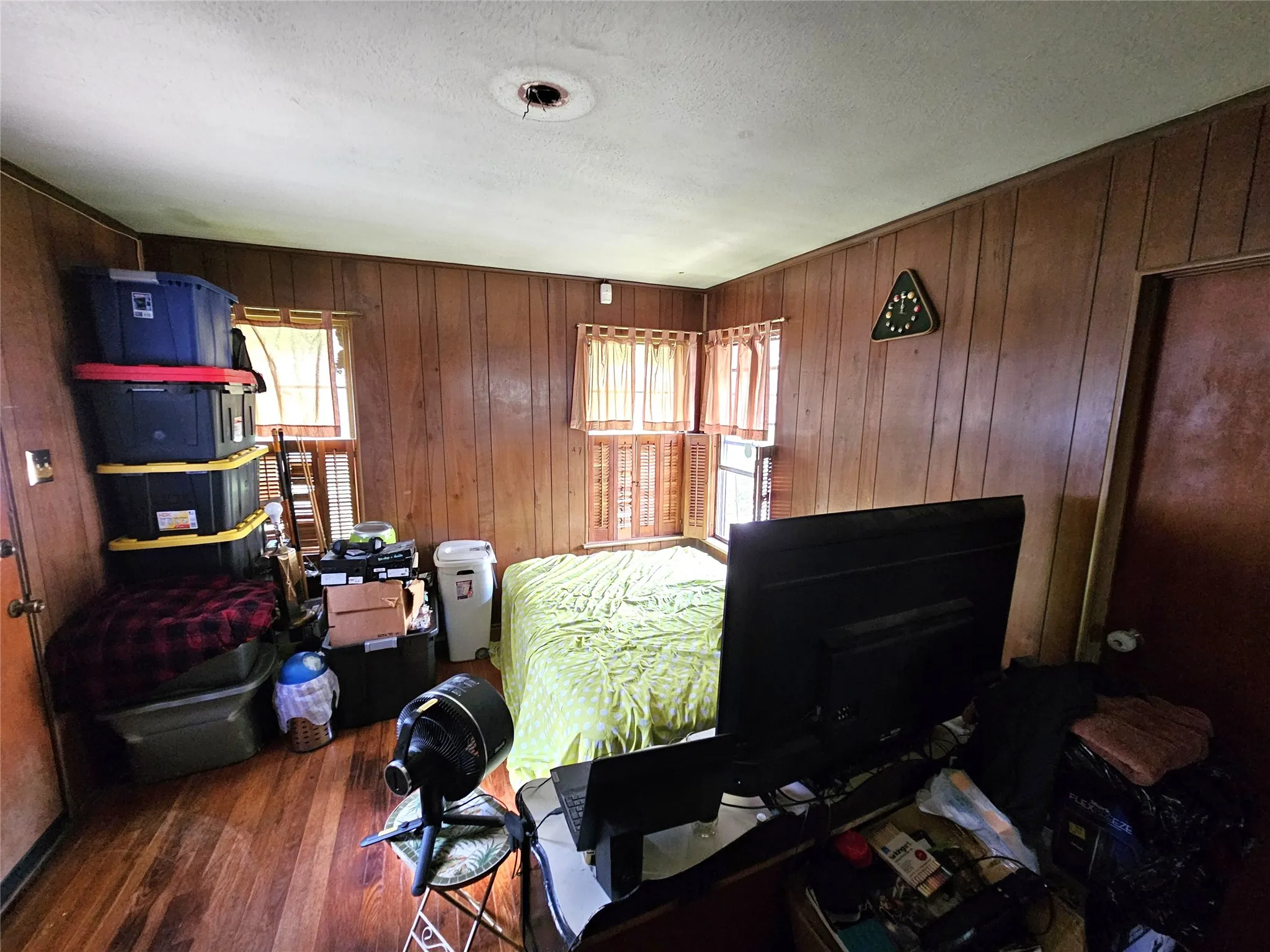 Room featuring wood-finish paneling, wood-finish flooring, and multiple windows