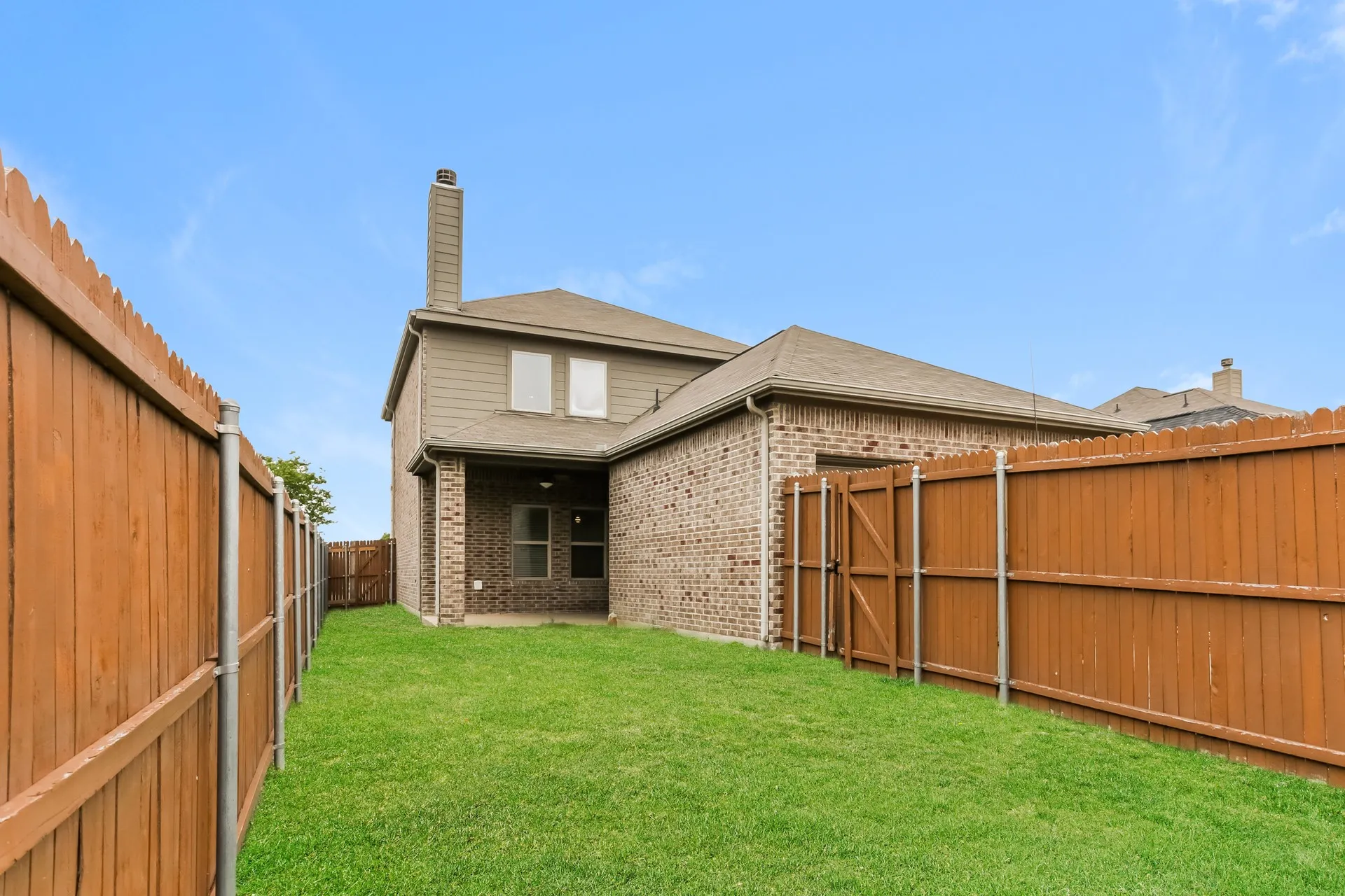 Spacious grass lawn bordered by wooden privacy fencing