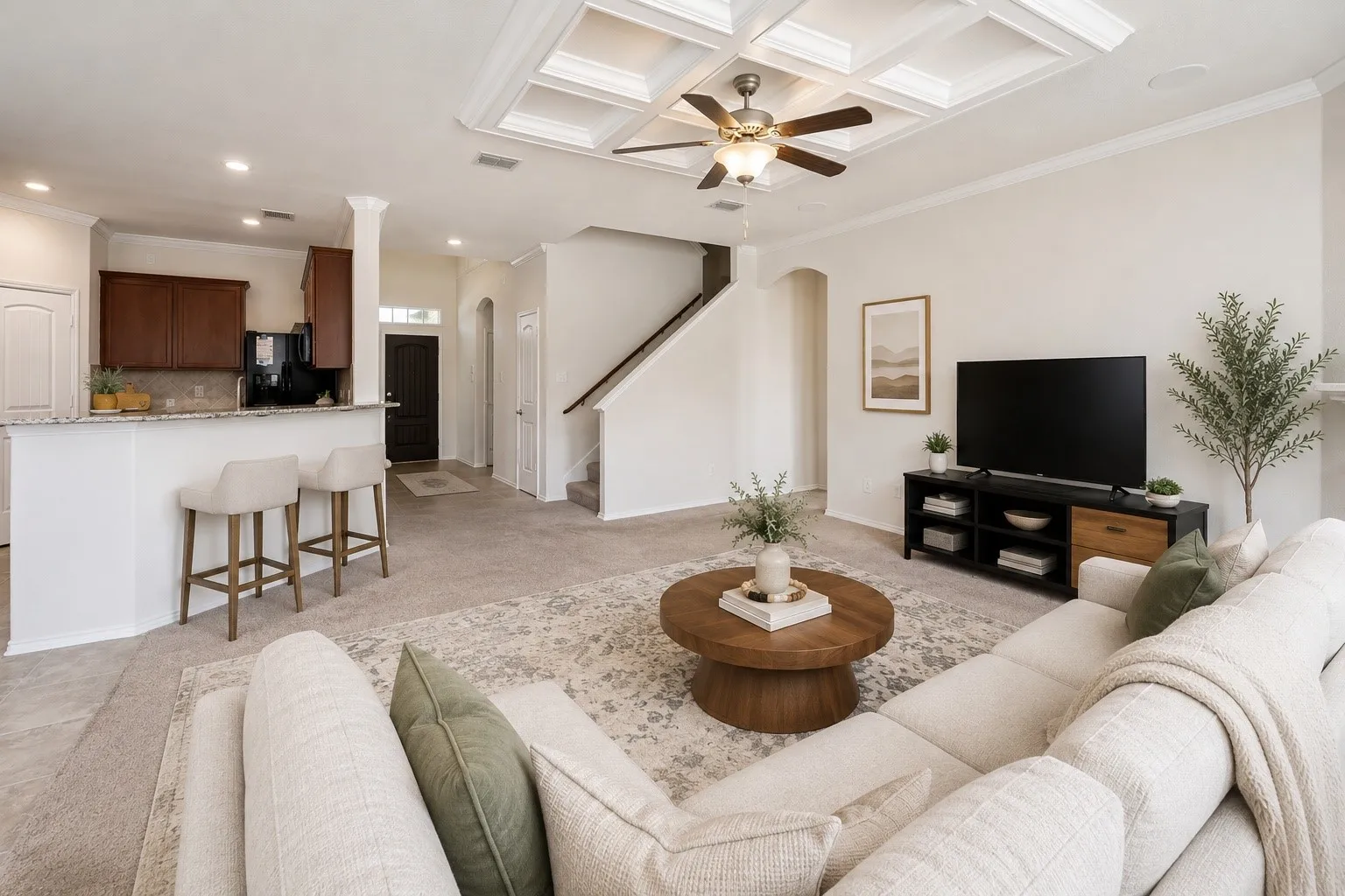 Open-concept living area featuring a coffered ceiling, ceiling fan, and carpeted flooring