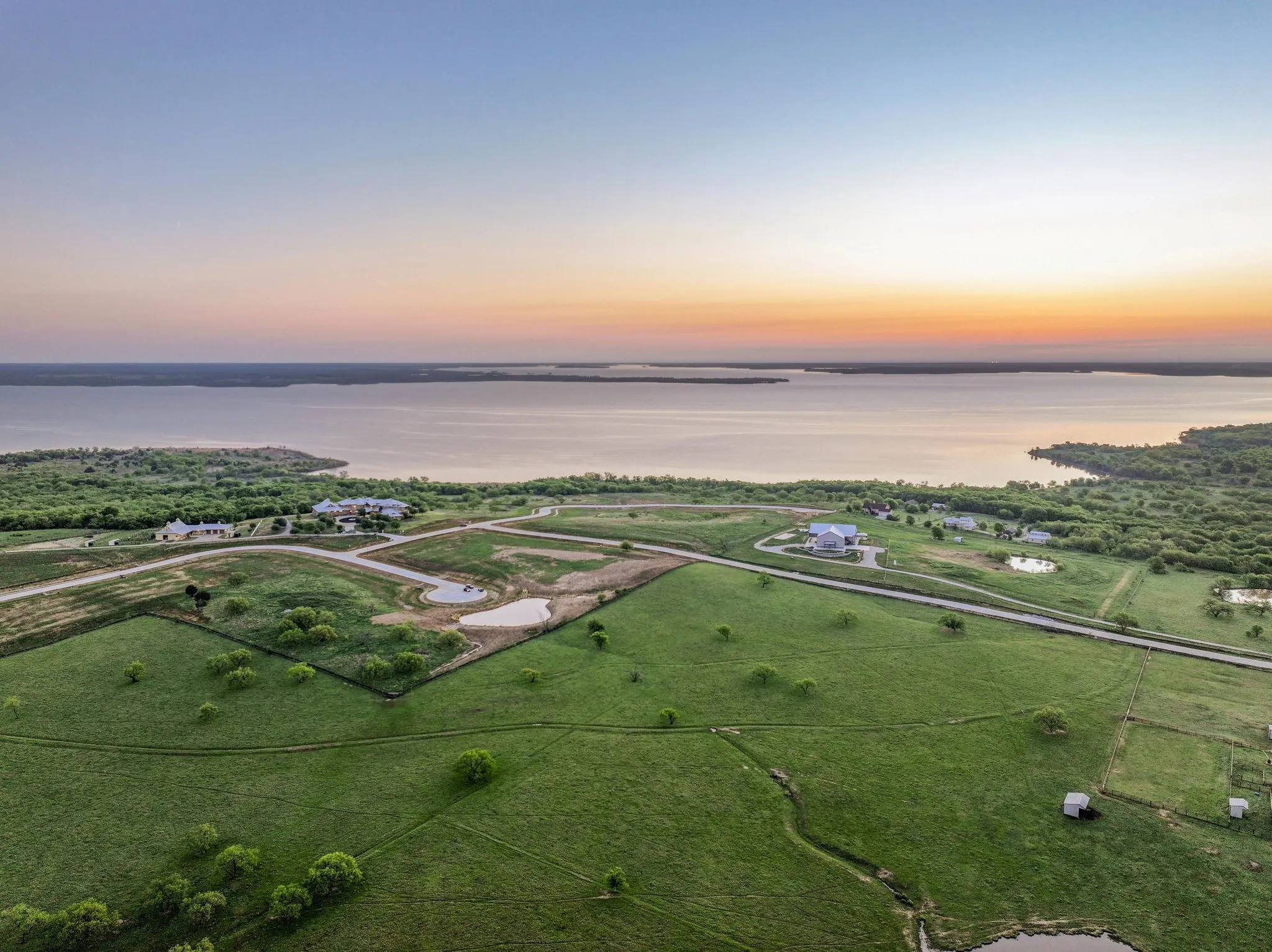 Expansive green landscape with a prominent lake in the background