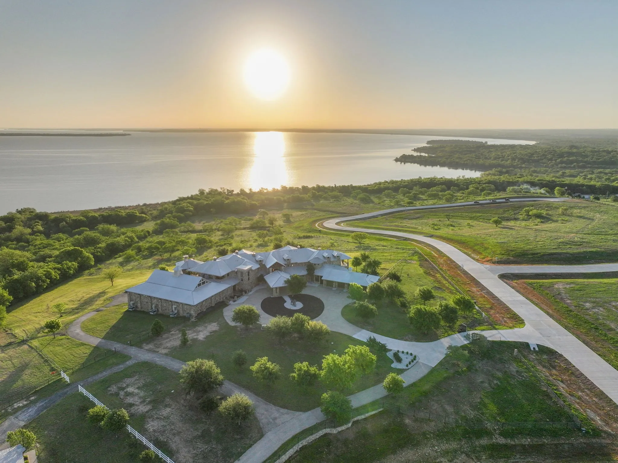 Expansive property featuring a stone exterior residence with multiple gables and a circular drive