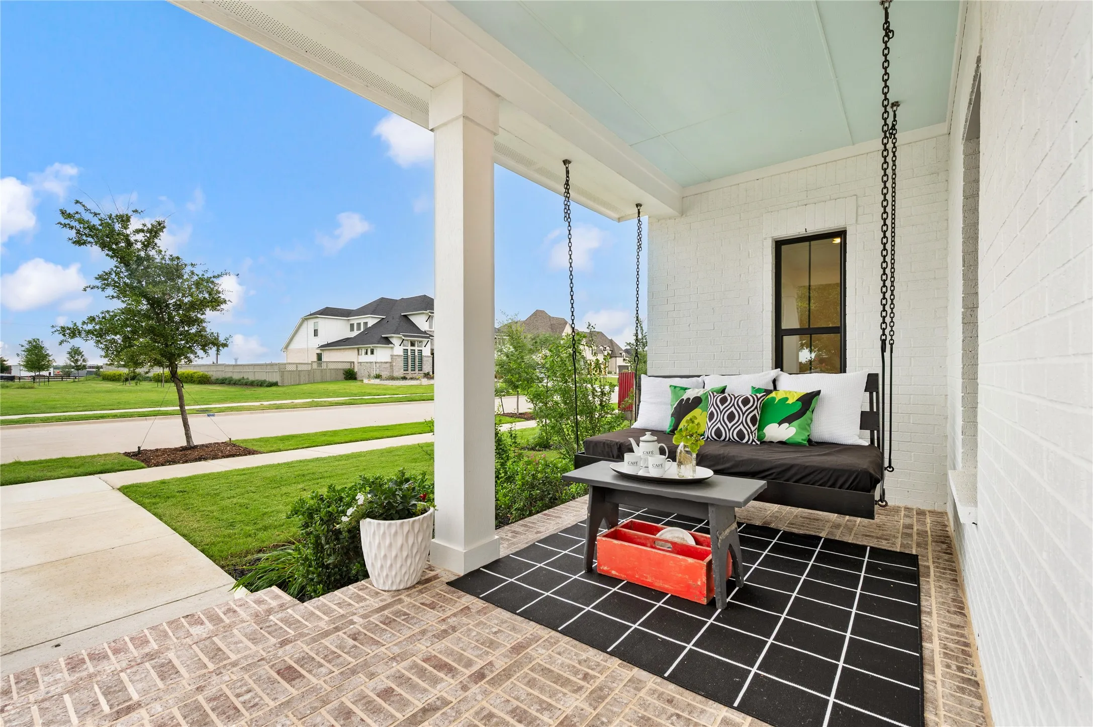 Gorgeous Farmhouse front porch with swing, brick patio overall and white painted exterior on a corner lot with peaceful views and no neighbors to the right or across from home!