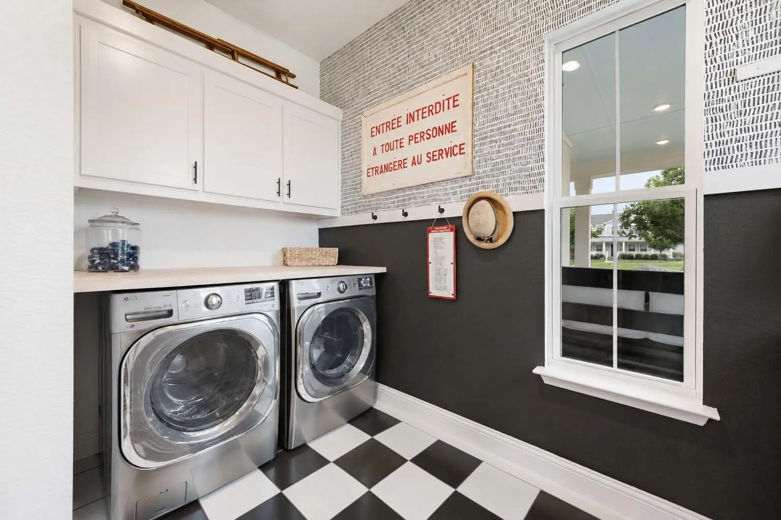 Custom dedicated and expanded laundry room with built in cabinets, tile flooring, utility sink and more