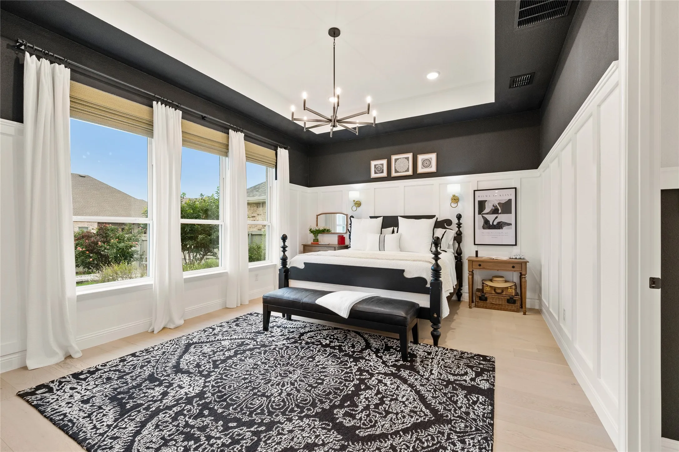 Gorgeous contemporary designed primary bedroom with wood flooring, custom wood work, built in storage, natural light and ensuite bathroom