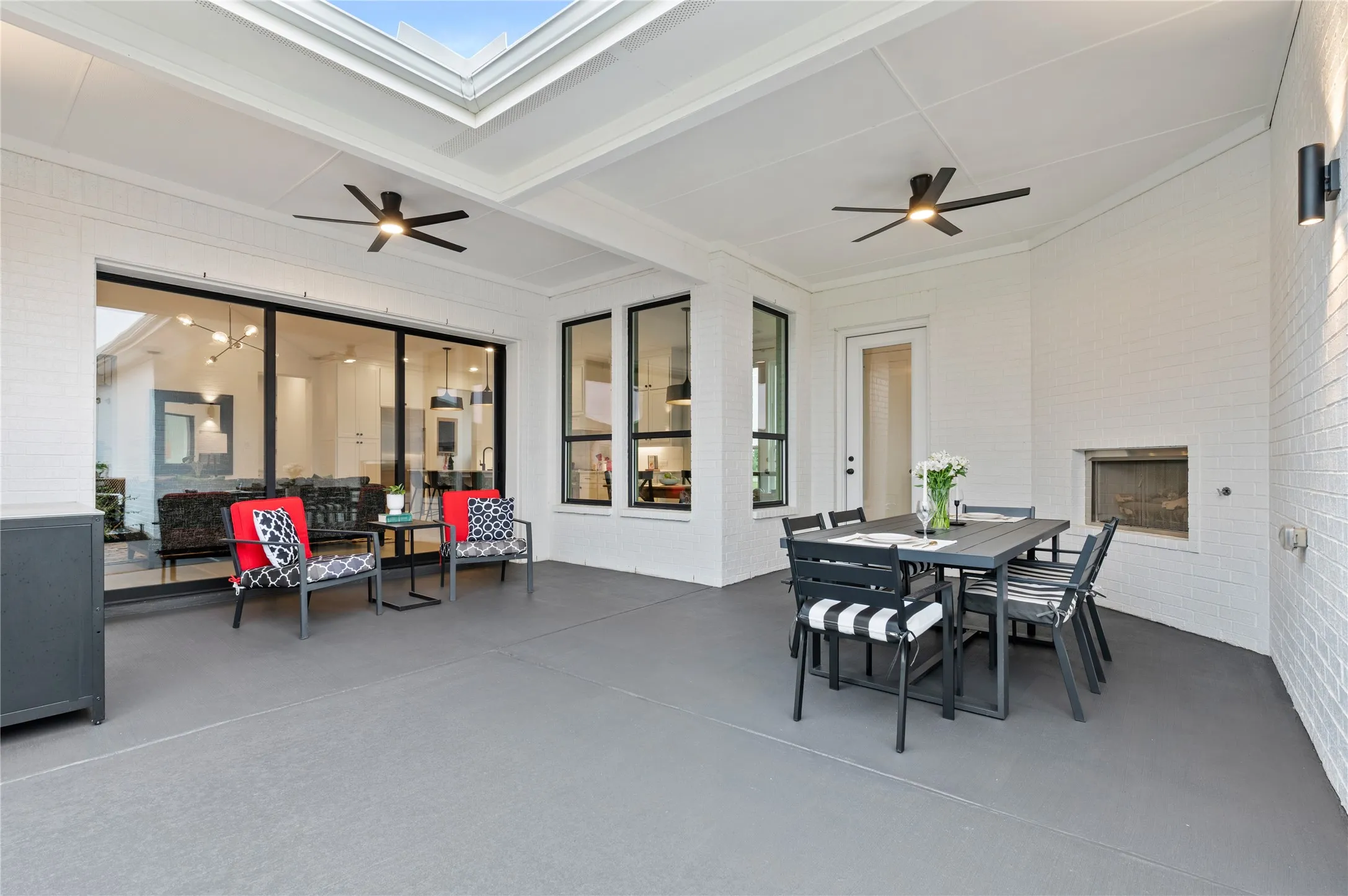 Expansive backyard featuring a stained and sealed oncrete patio, landscaped garden beds, stepping stone pathways and a well-maintained lawn with covered outdoor seating and a fireplace.