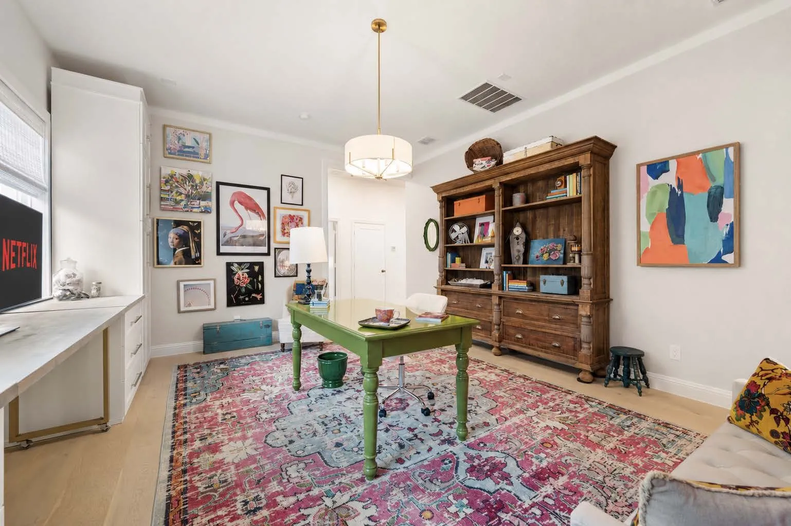 Family room that could be used as a movie room, additional office, etc. with natural lighting, custom paint, built in cabinets and drawers