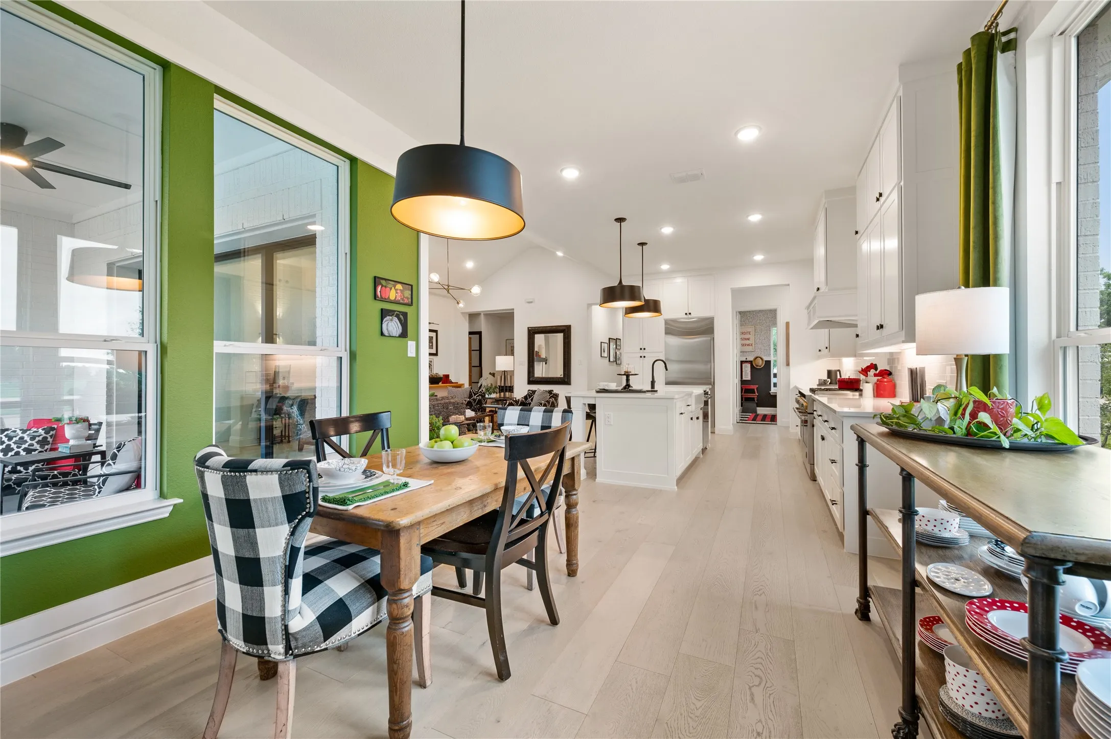 Open-concept kitchen and breakfast area featuring light wood flooring, custom paint, fixtures, hardware and more