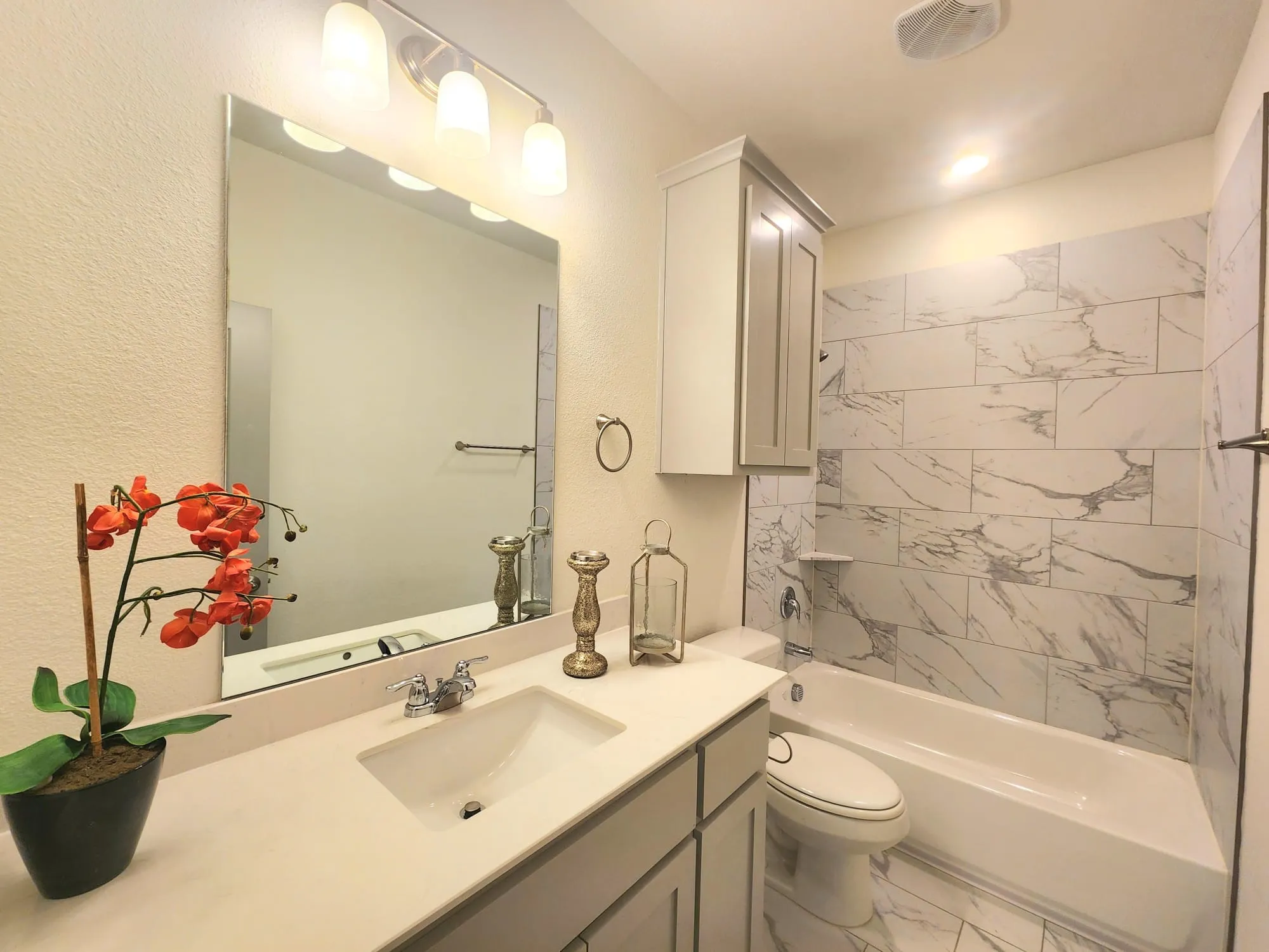 Bathroom featuring a single vanity with an integrated sink, chrome faucet, and light-colored countertop