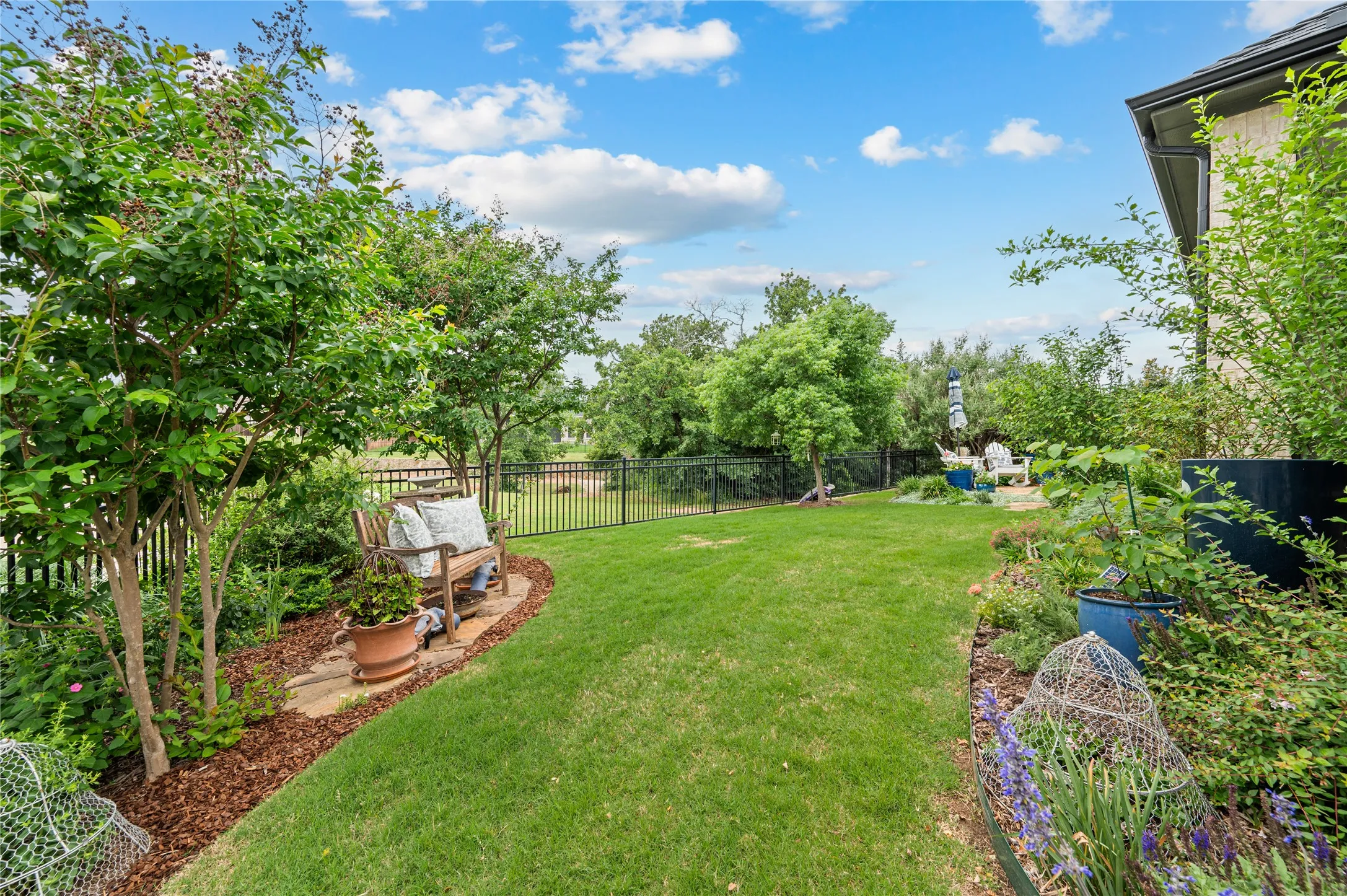 Rear exterior featuring a screened patio with a brick paver seating area, surrounded by diverse plantings, the natural side of wildridge and no neighbors!