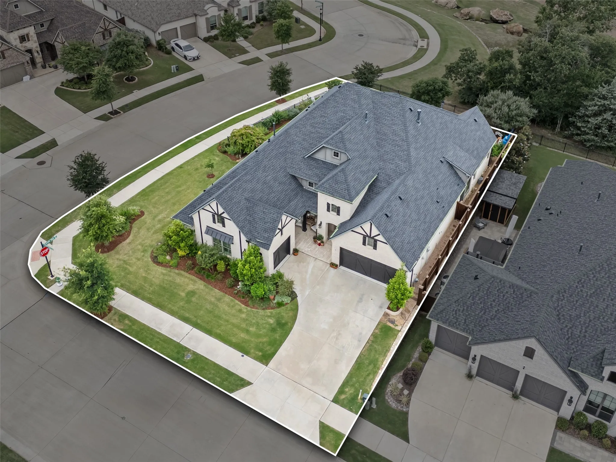Tudor-style residence with a dark shingle roof and light-colored siding, featuring multiple gables and a covered entry