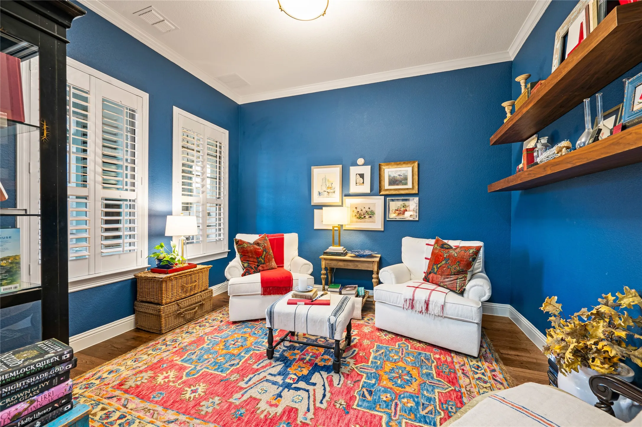 Formal office off the front entry with custom paint, wood flooring and plantation shutters.
