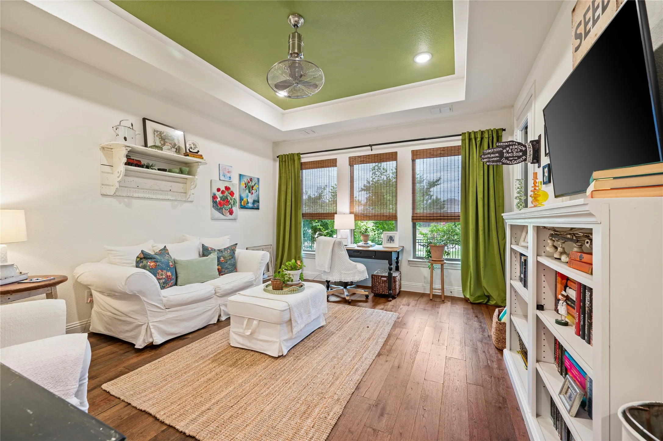 Spacious game room with tray ceiling, custom paint, additional add on door leading to screened in patio.