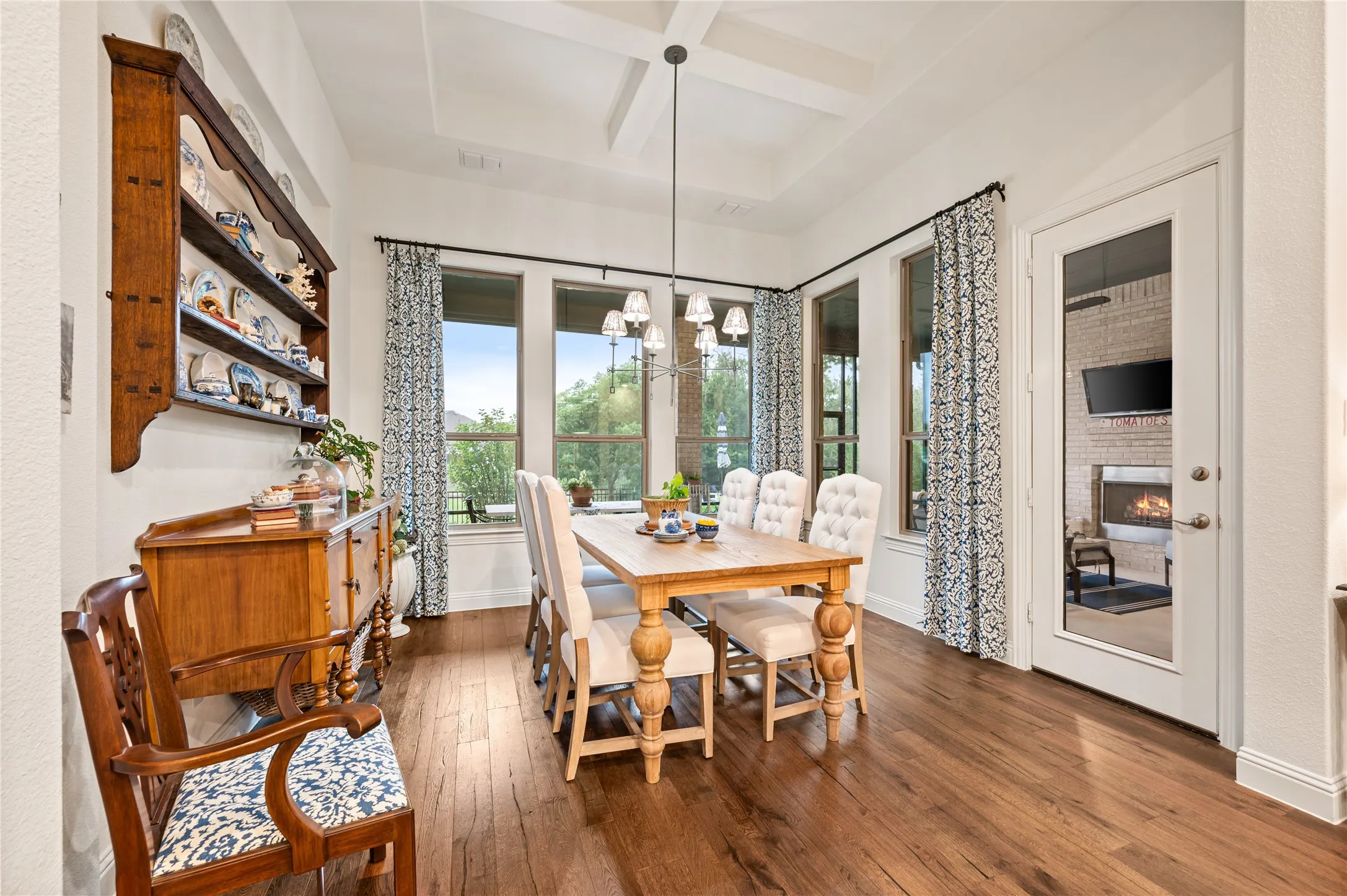 Dining space with coffered ceiling, custom lighting and plenty of natural light