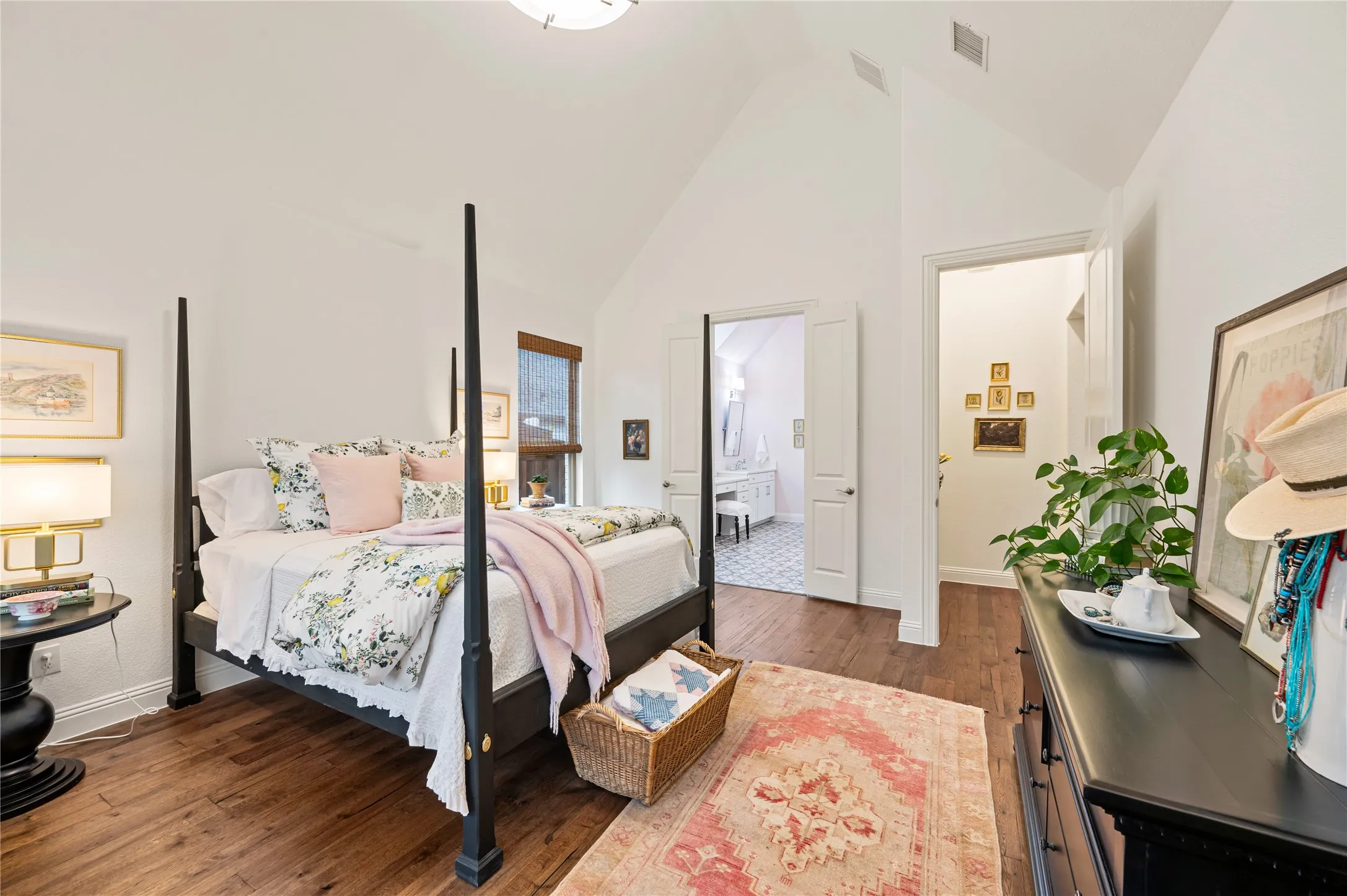 Vaulted ceiling bedroom featuring wood-finish flooring