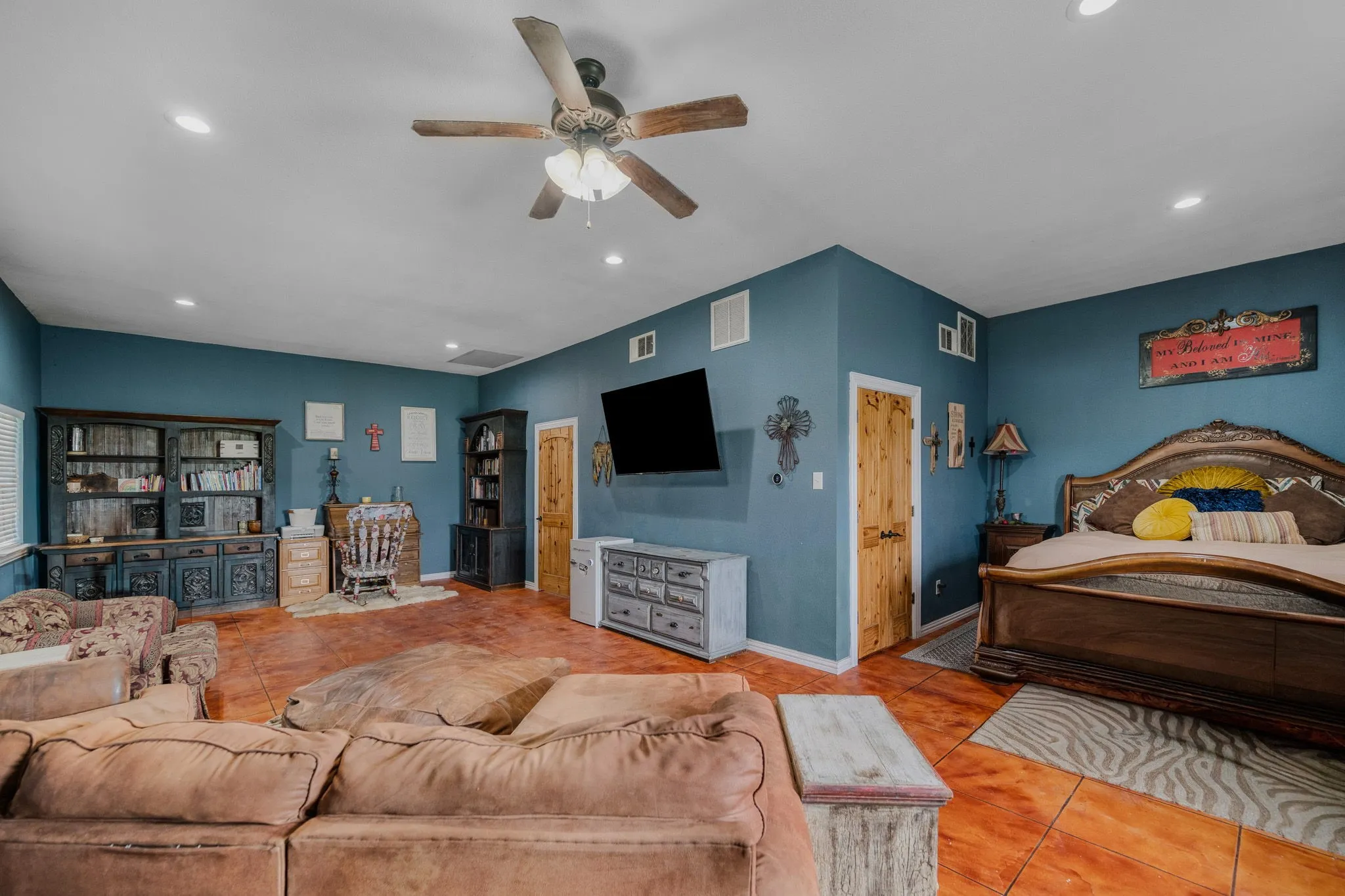 Spacious room featuring rich blue walls and a multi-toned tile flooring