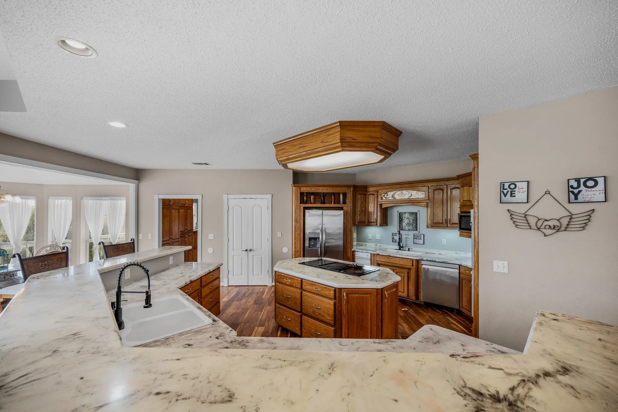 Kitchen featuring a large U-shaped counter with an integrated sink and black gooseneck faucet