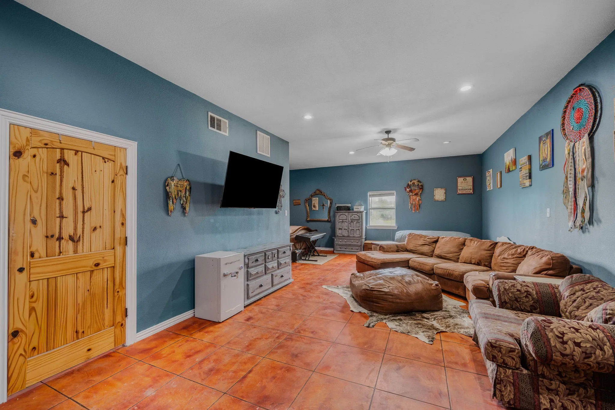 Spacious interior room featuring terracotta-toned tile flooring and painted walls