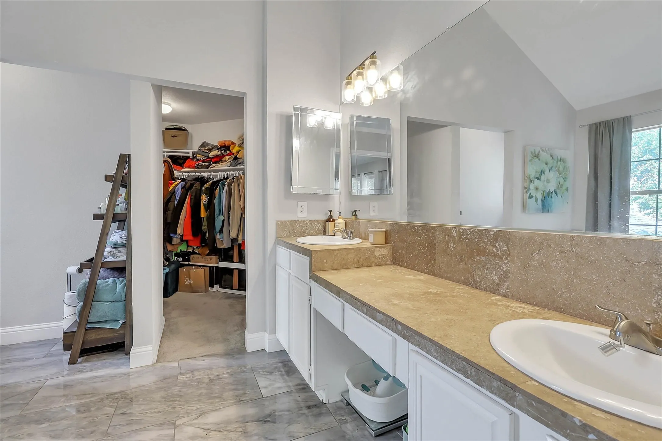 Bathroom featuring a double vanity with integrated sinks, stone-finish countertops, and a full-width mirror