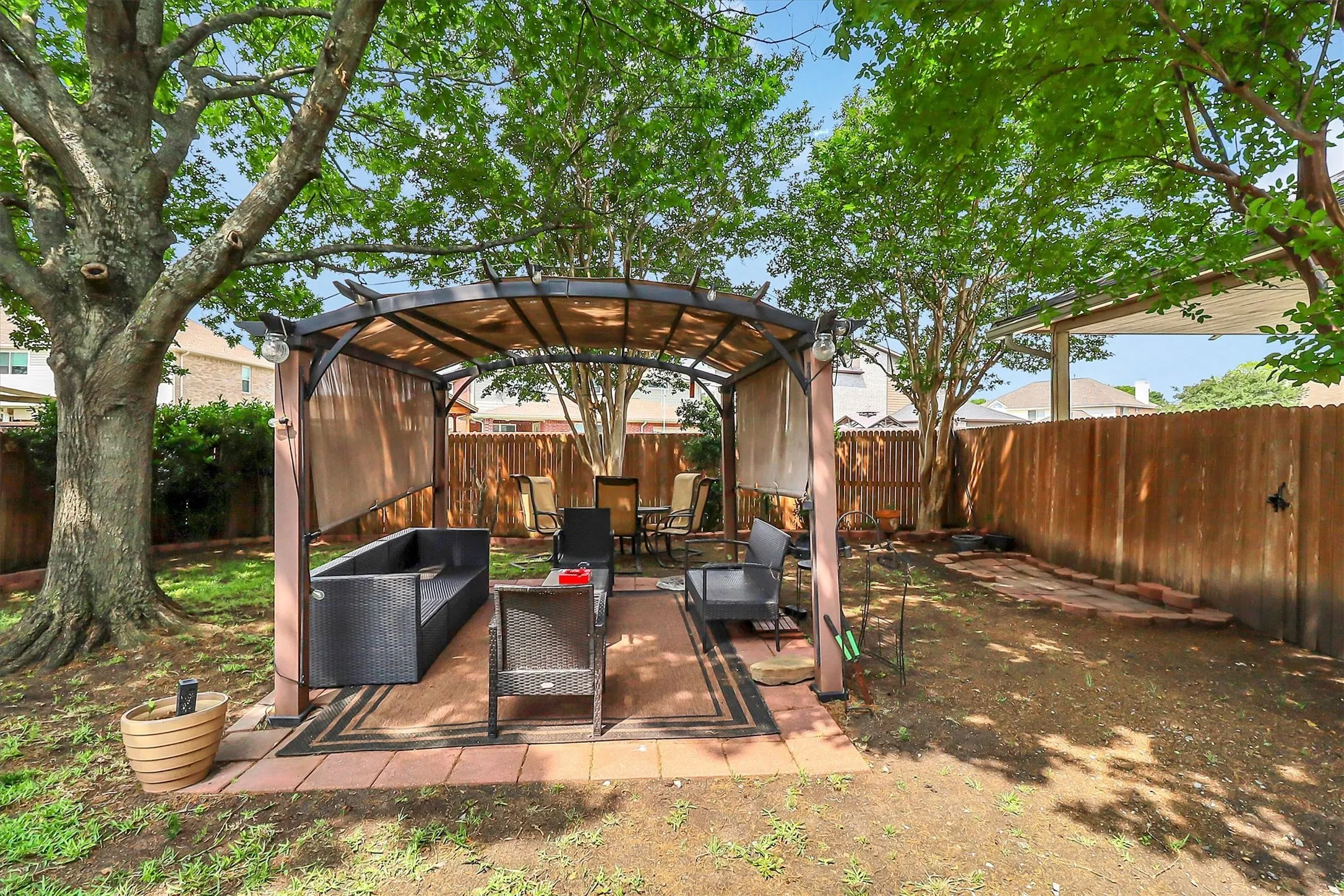Backyard featuring a covered patio structure with a fabric canopy and privacy screens