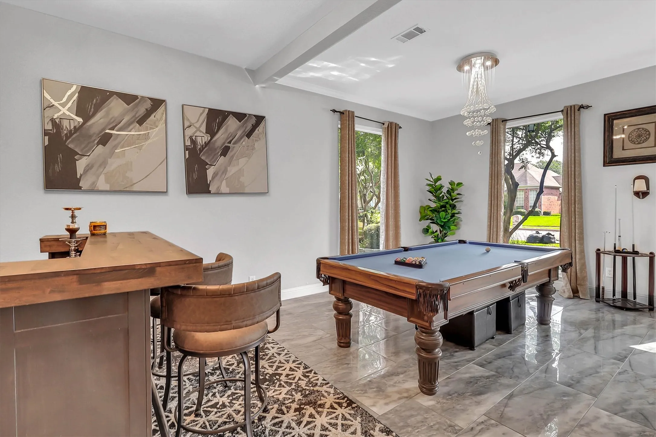 Open concept room featuring a built-in bar with wood-finish countertop, a billiards table, and large windows