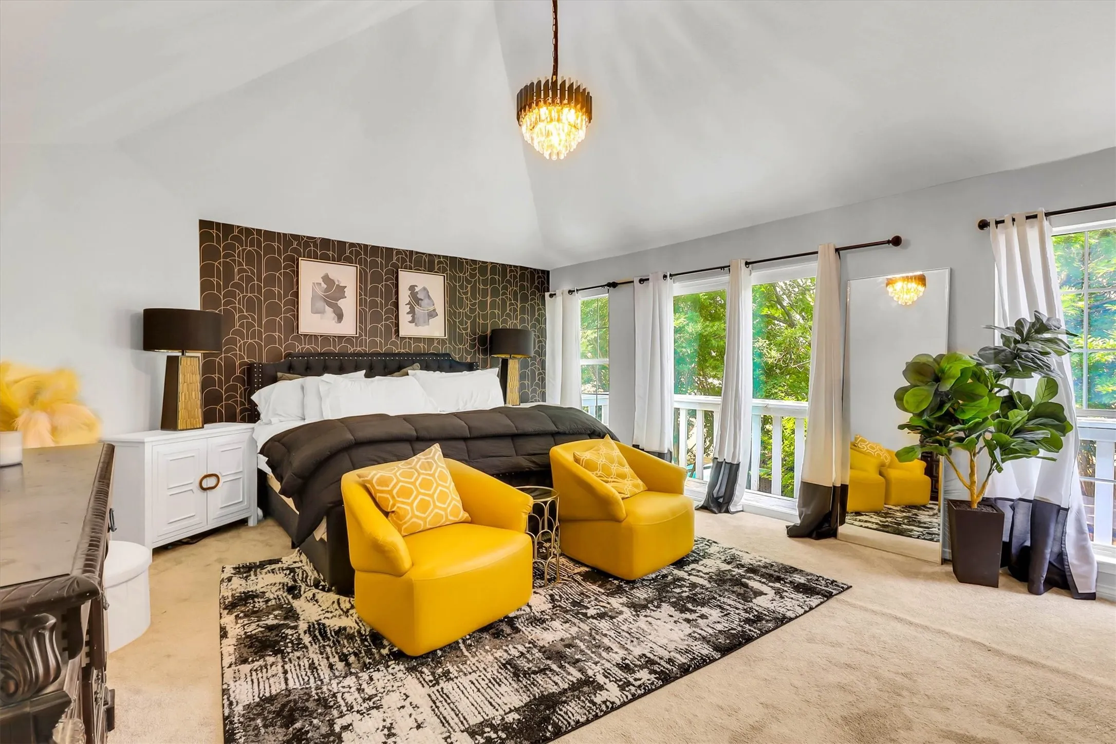 Vaulted ceiling bedroom with a patterned accent wall and multiple large windows