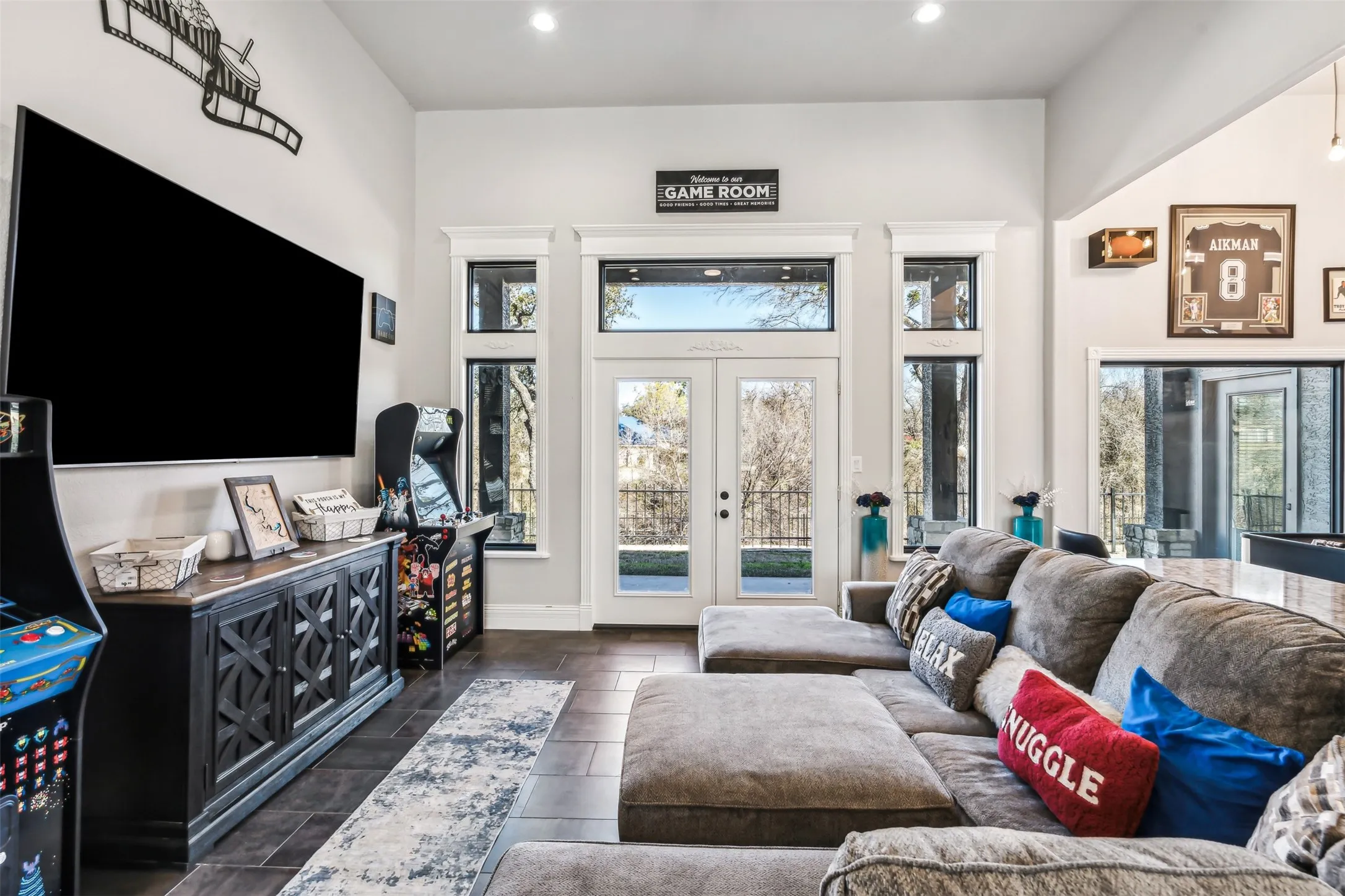 Spacious room featuring high ceilings, dark wood-finish flooring, recessed lighting, and white trim