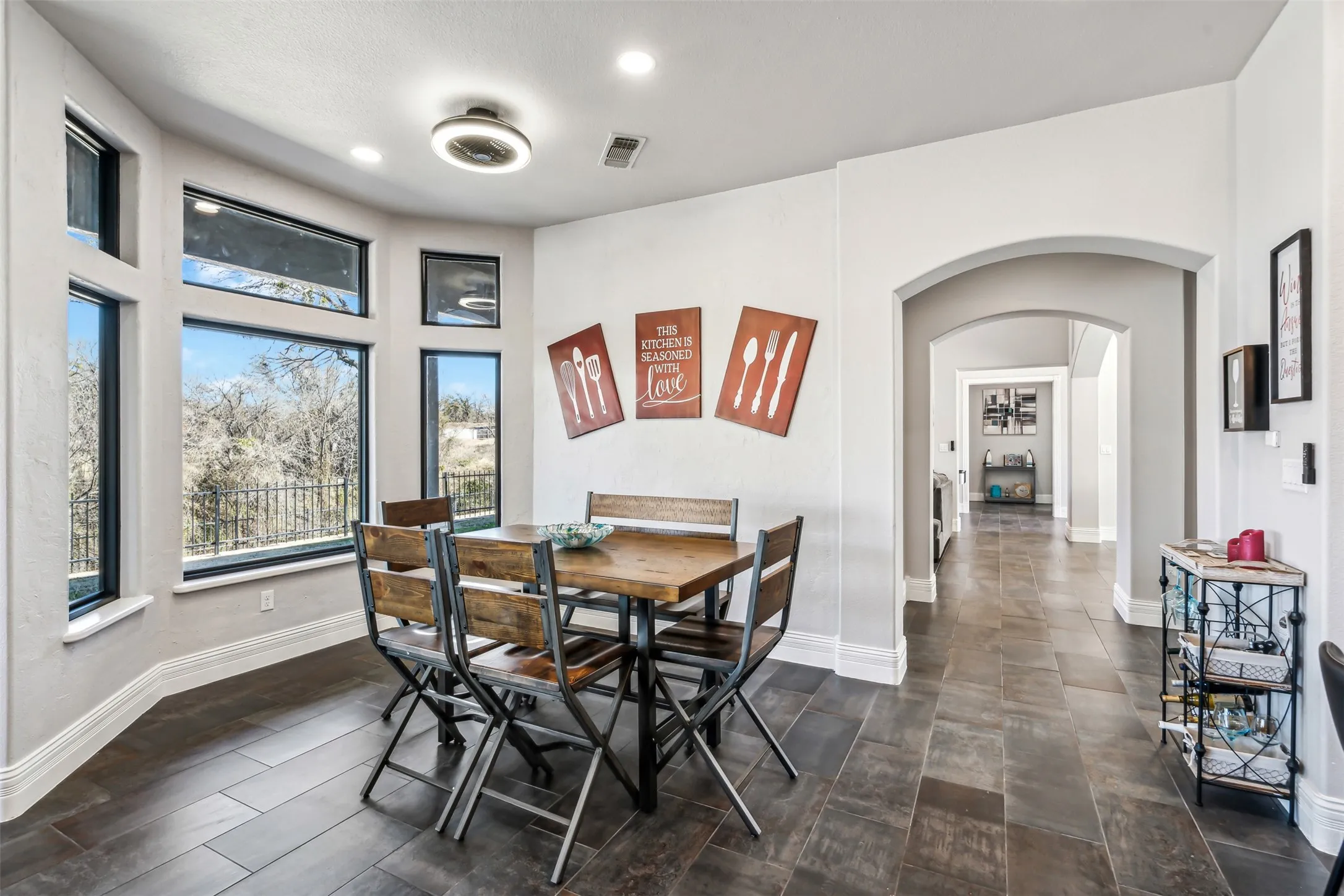 Dining area featuring dark wood-finish flooring and a bay window with multiple panes
