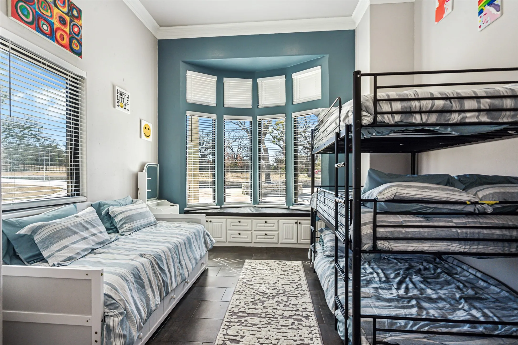 Room featuring a bay window with a built-in window seat and storage cabinetry