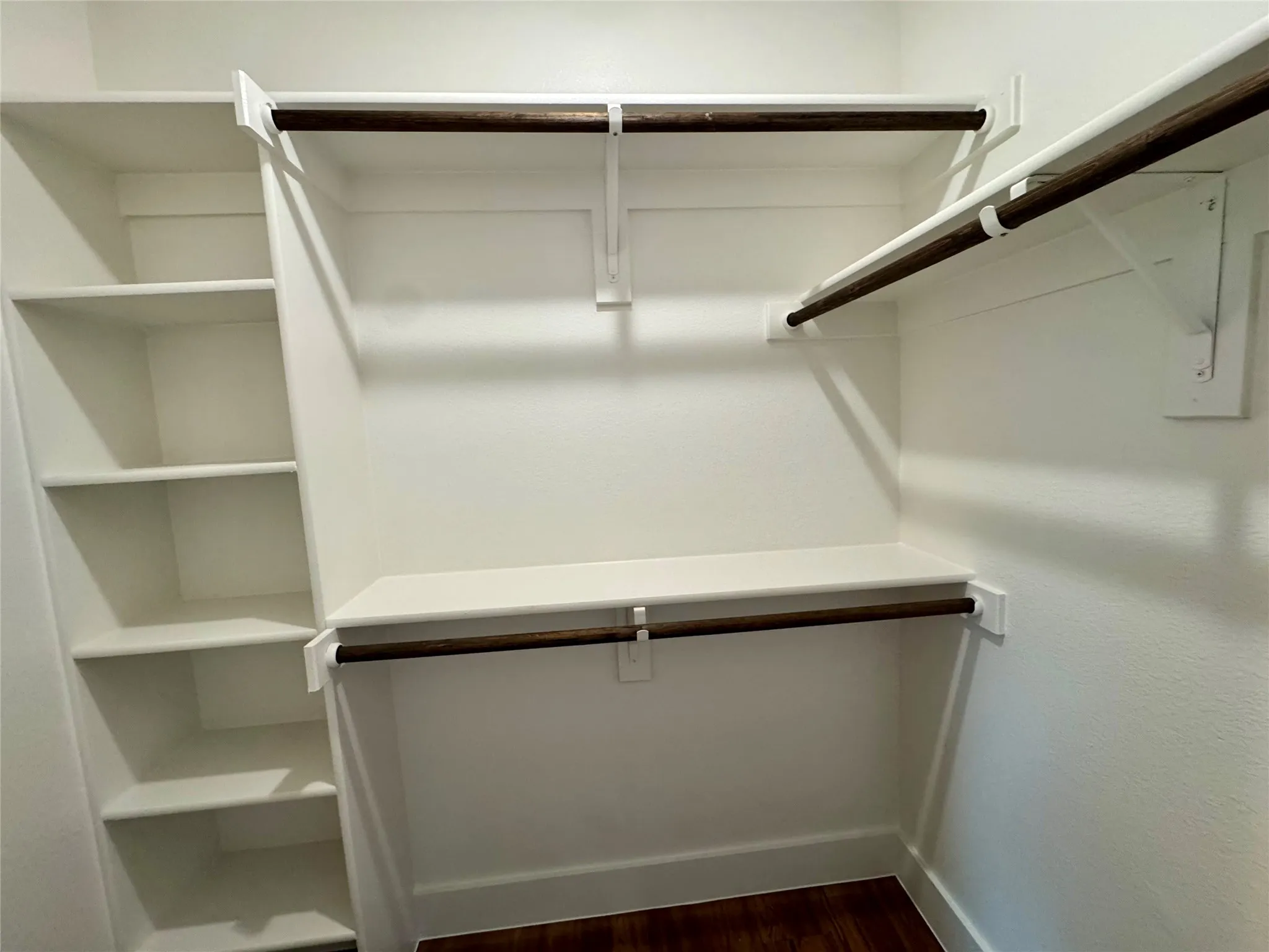 Walk in closet featuring dark wood-style floors
