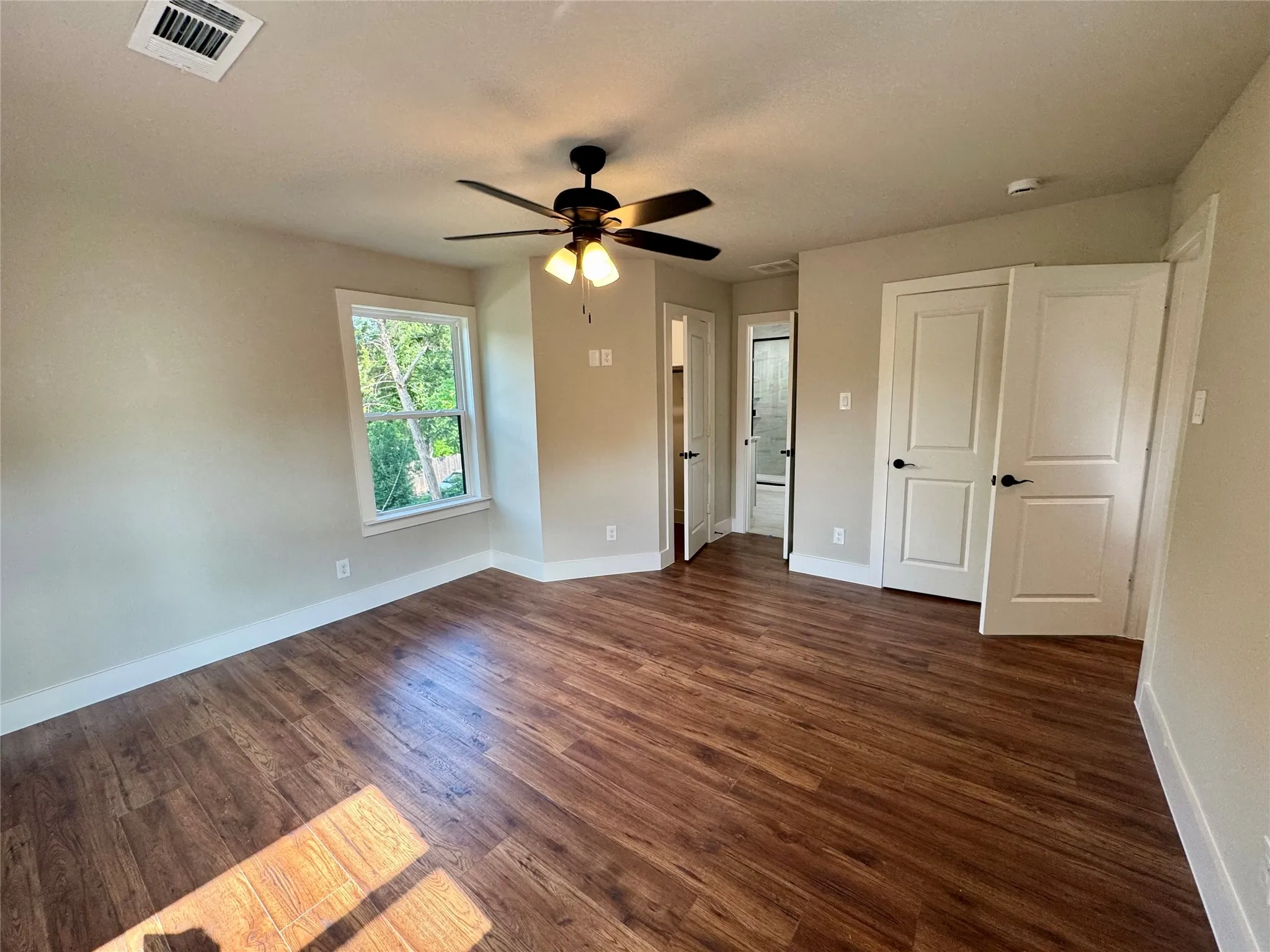 Unfurnished bedroom featuring dark wood-style flooring and ceiling fan