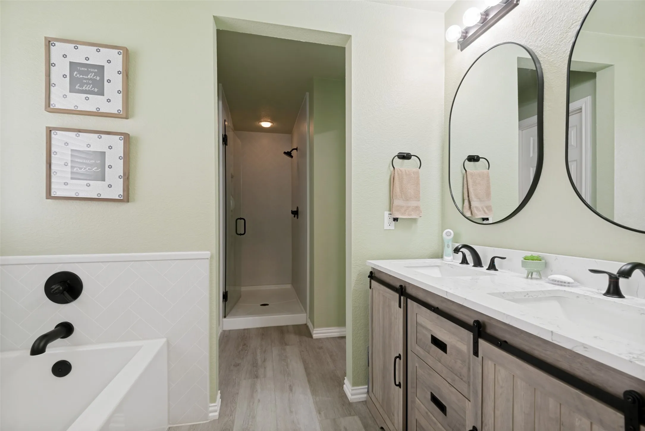 Modern bathroom featuring a dual vanity with wood-finish cabinetry and quartz countertops