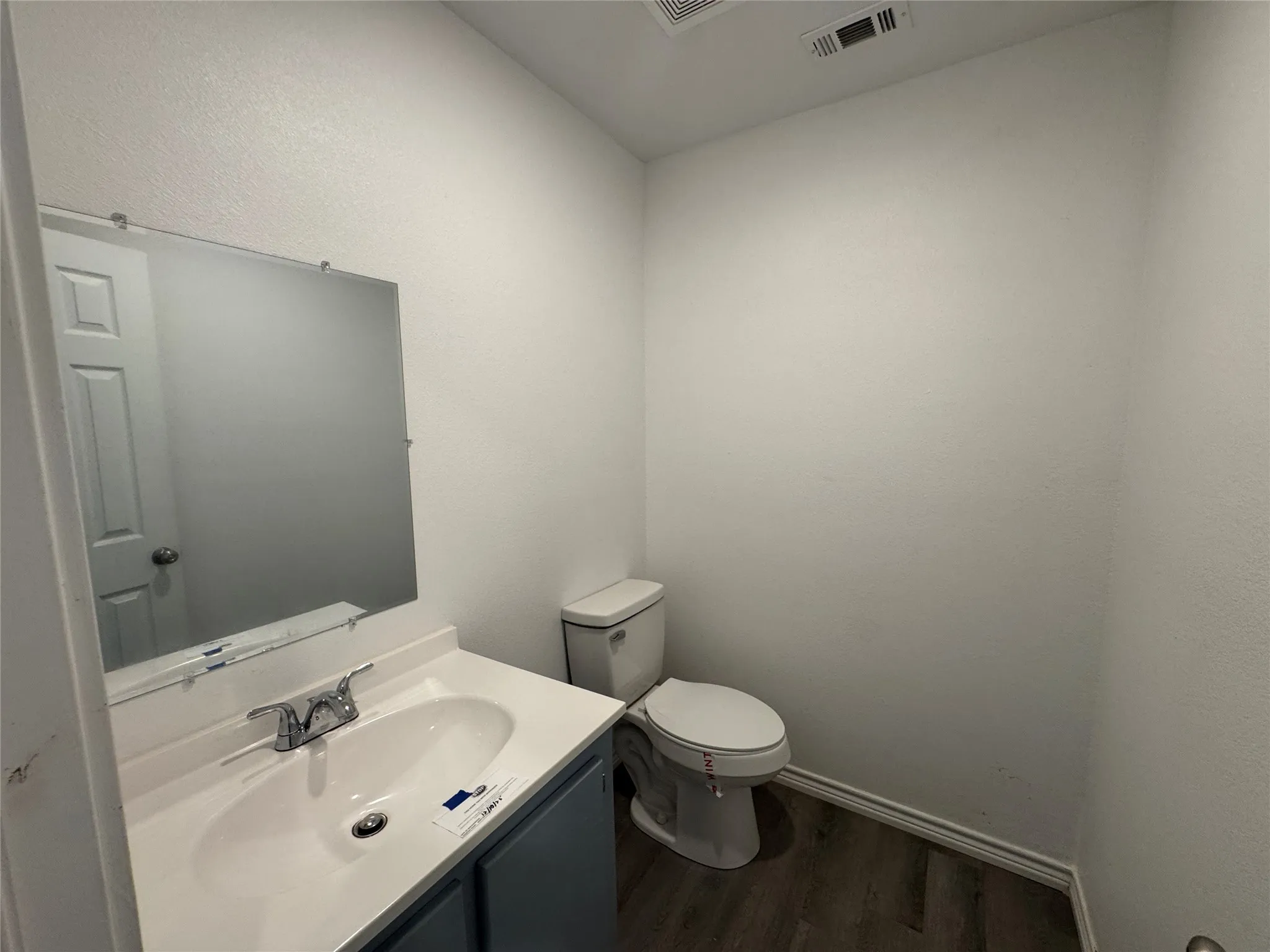 White vanity with integrated sink and chrome faucet, set against a large wall-mounted mirror