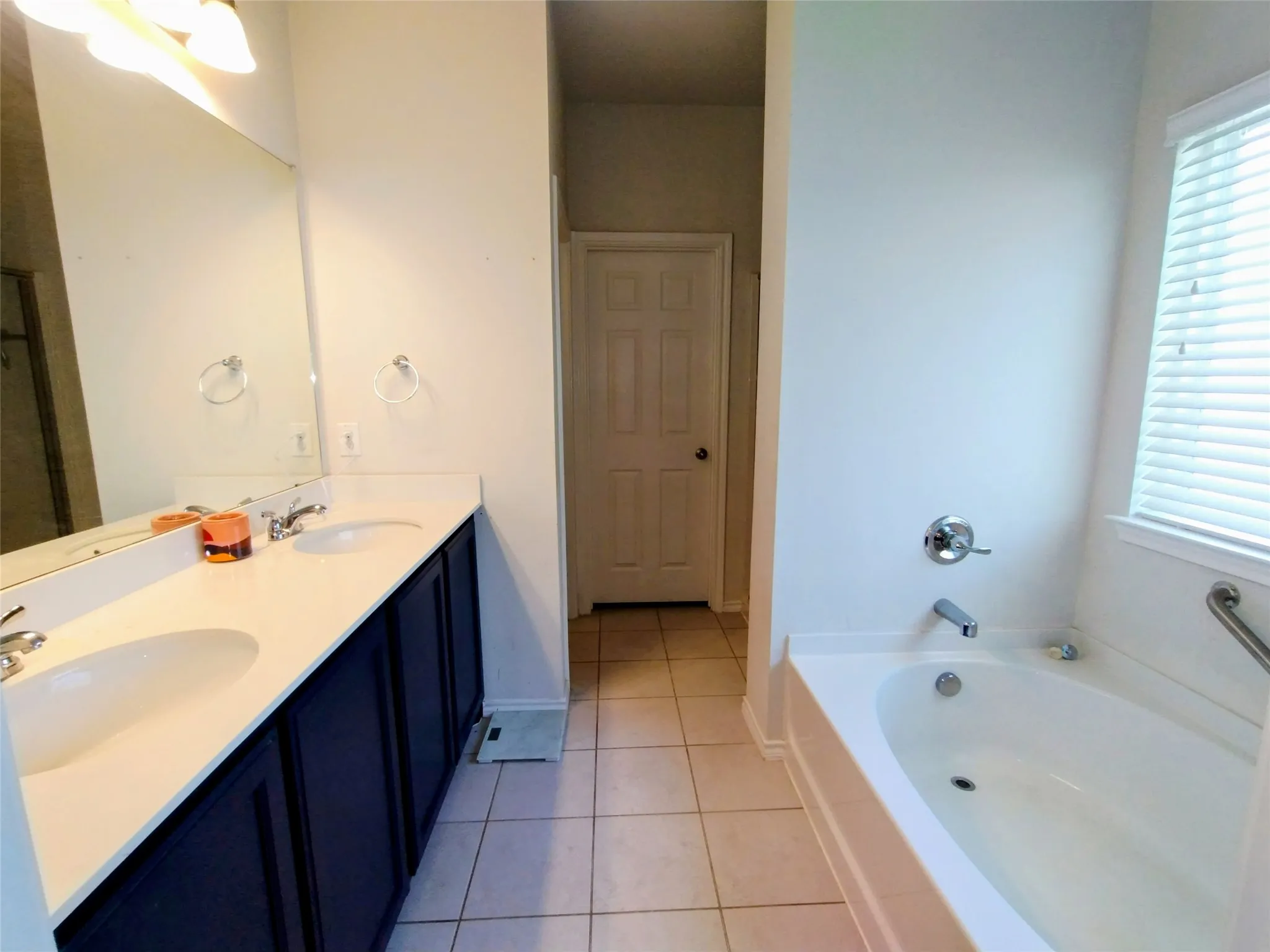 Bathroom featuring vanity, a tub to relax in, and tile patterned floors