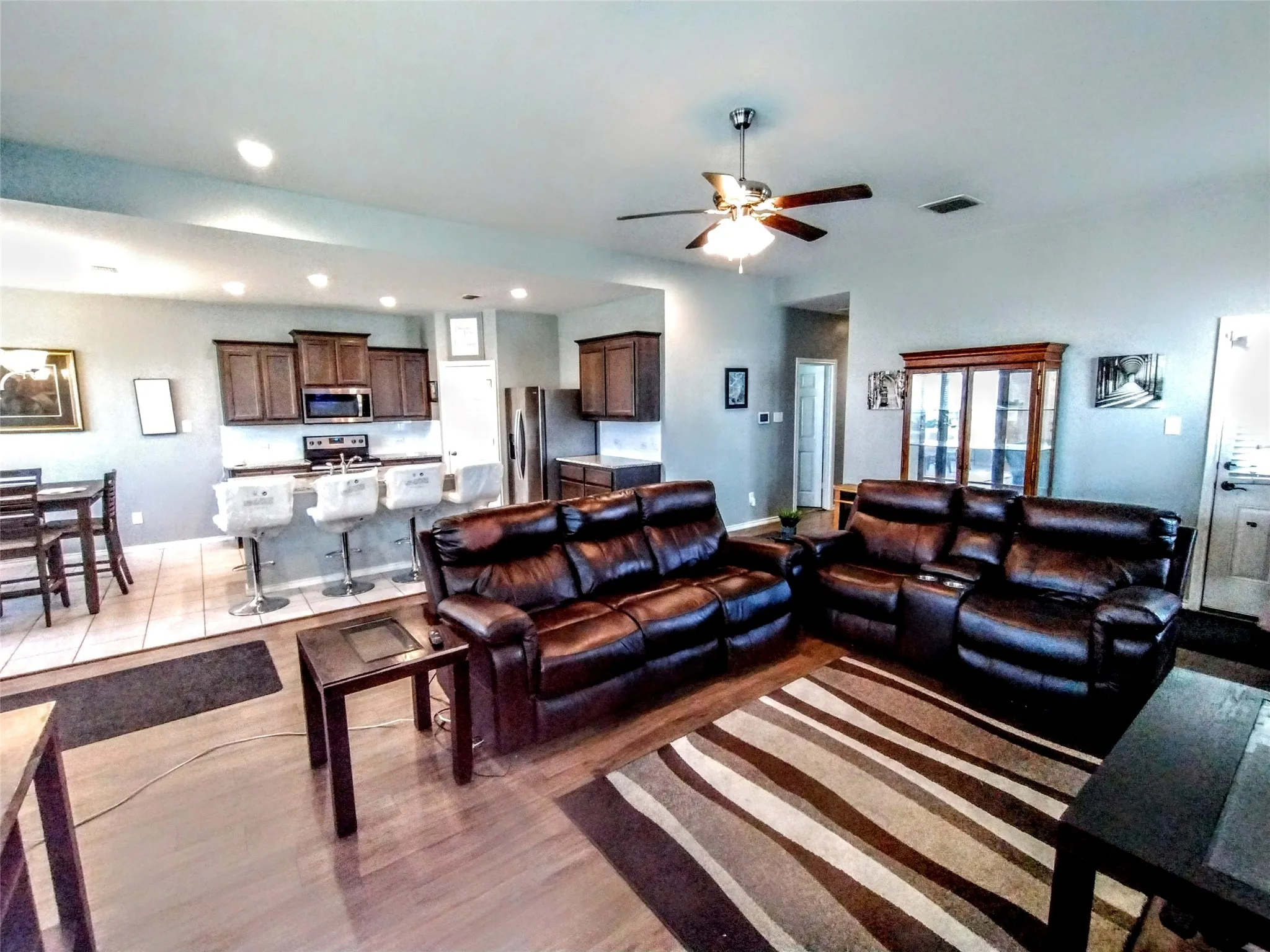 Living room with ceiling fan and light hardwood / wood-style flooring