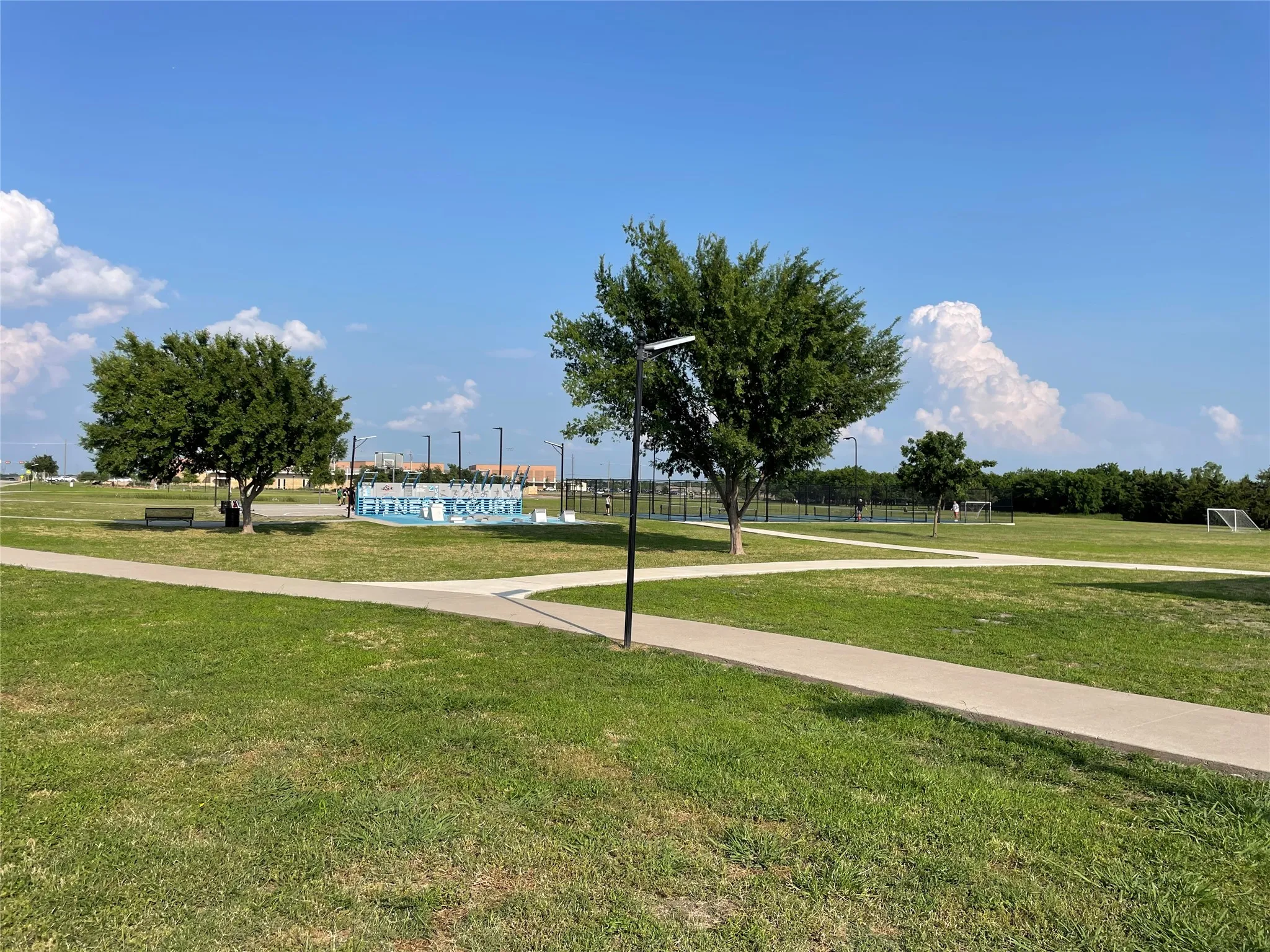 Fitness Court, Pickleball Court and Soccer Field. Trees in the Background Border Frisbee Golf Course. Great Walking Trails Throughout!