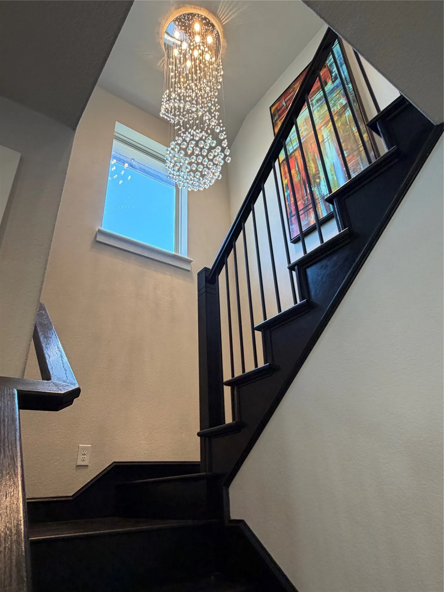 Wood Staircase with Iron Balusters. Unique Modern Light Fixtures Throughout