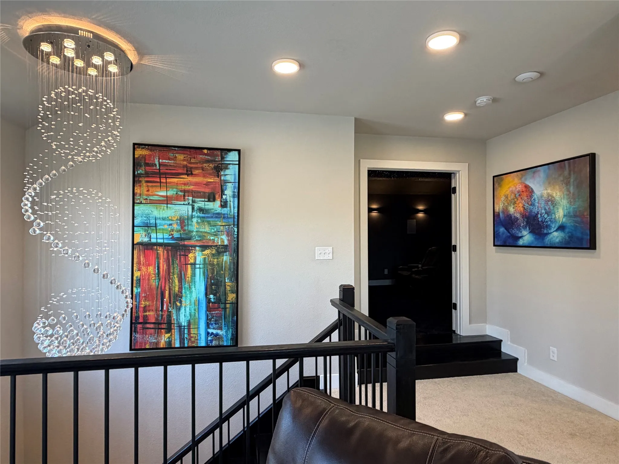 Wood Staircase with Iron Balusters. Unique Modern Light Fixtures Throughout