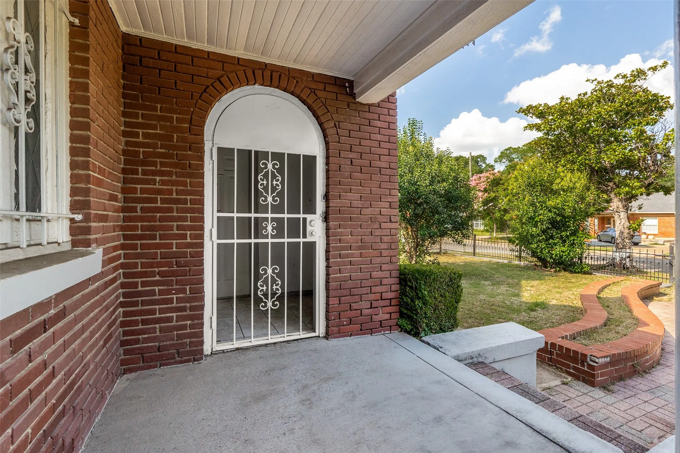 Brick facade with an arched entry and security door