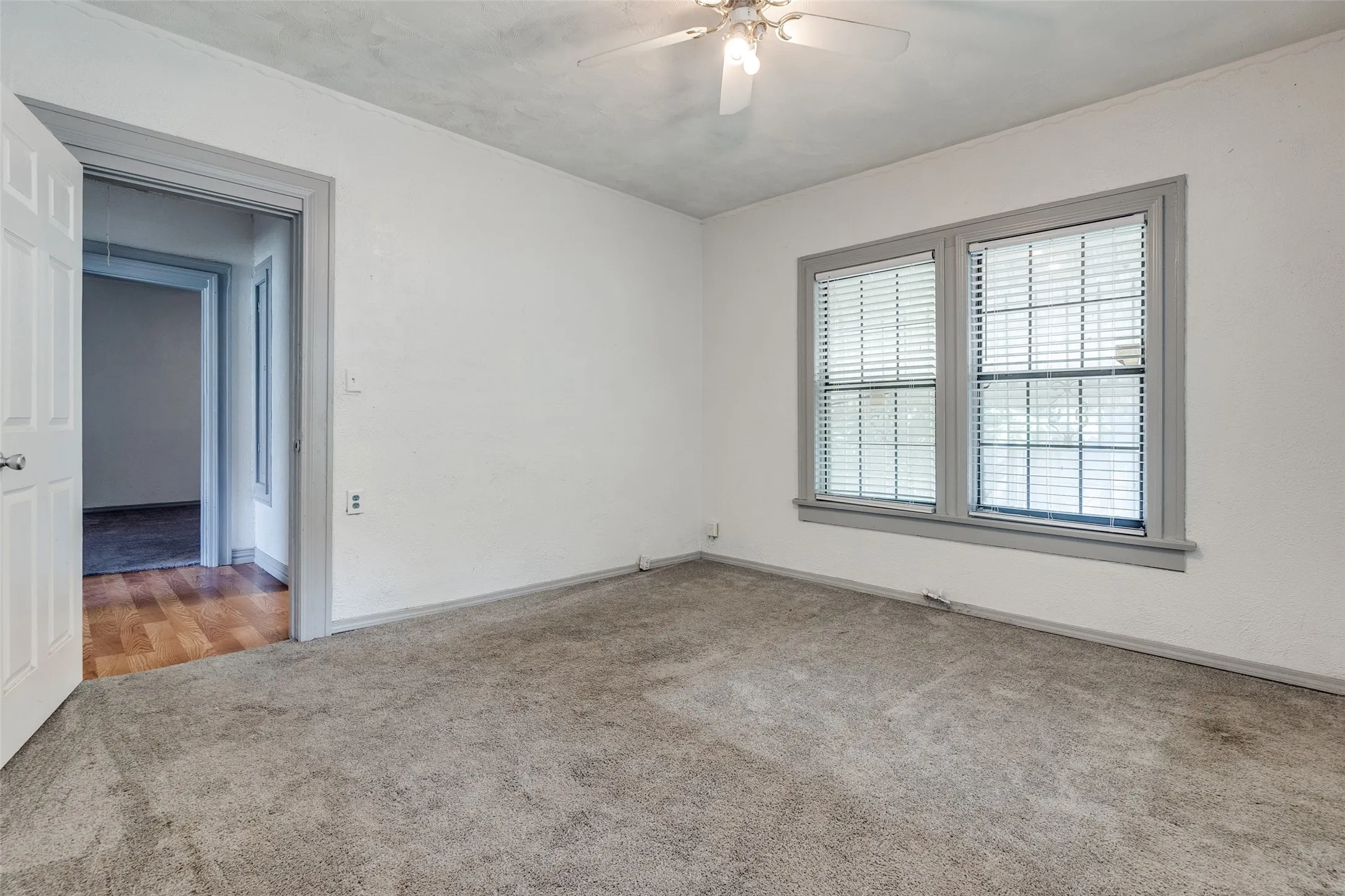 Neutral tone carpeted room with white walls and gray trim
