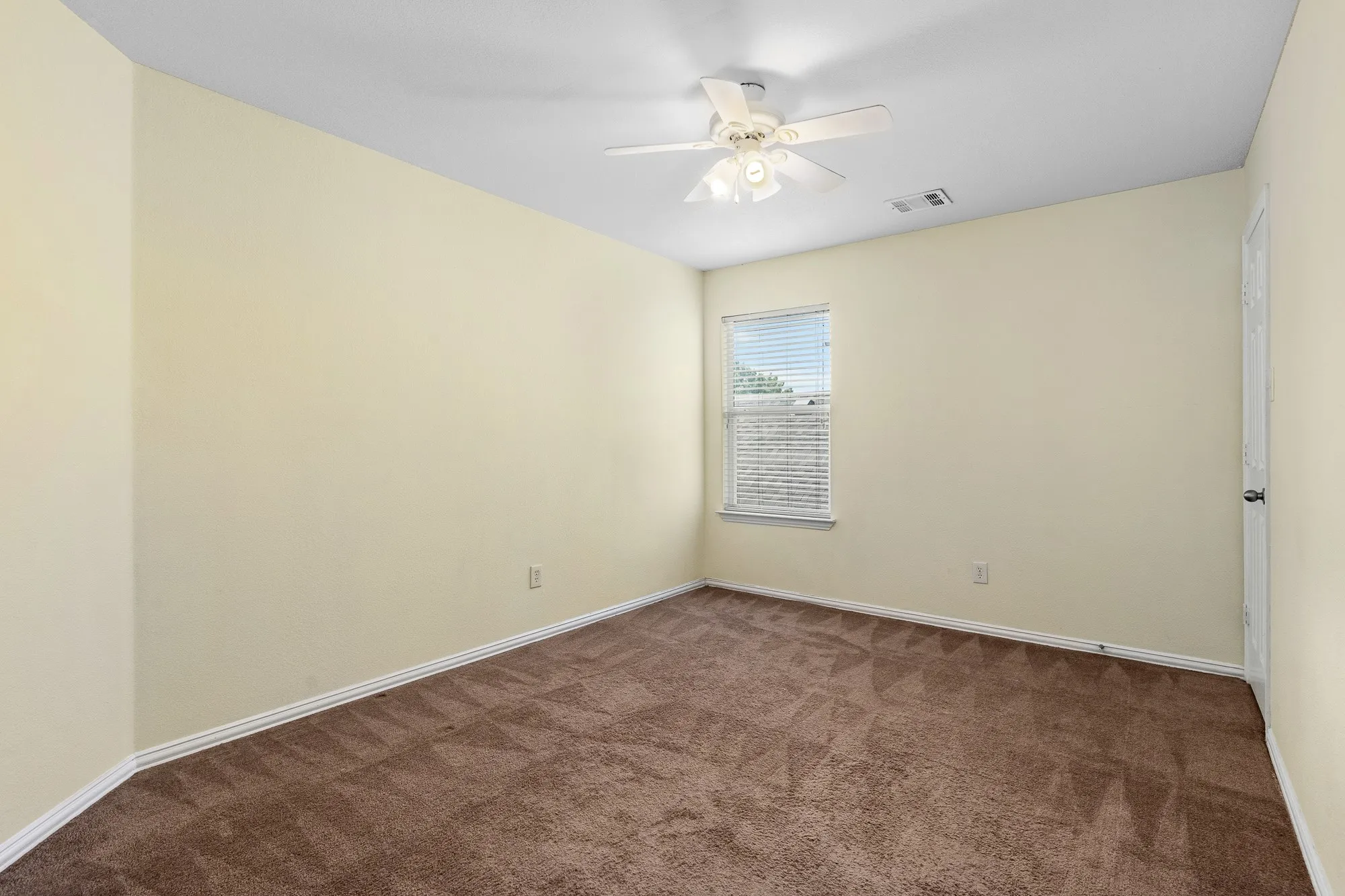 Cream-painted walls with white trim and brown carpet