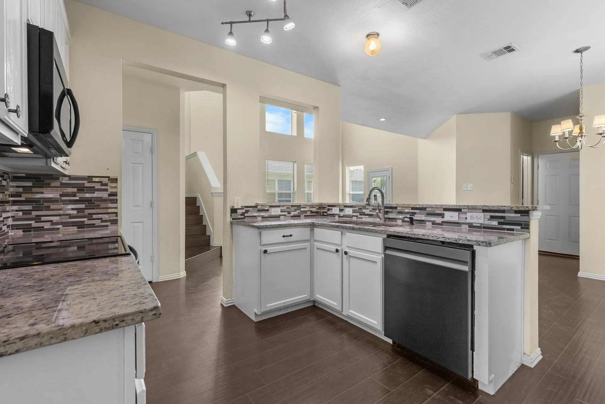 Kitchen featuring granite countertops, white cabinetry, and a mosaic tile backsplash