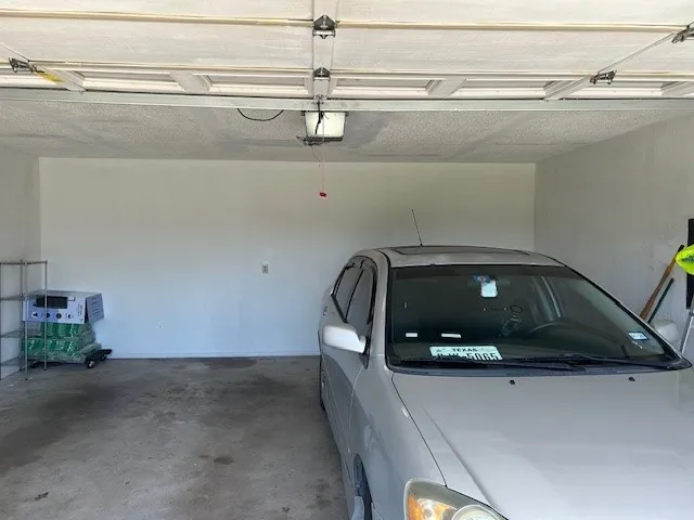 Attached garage with concrete flooring and painted walls